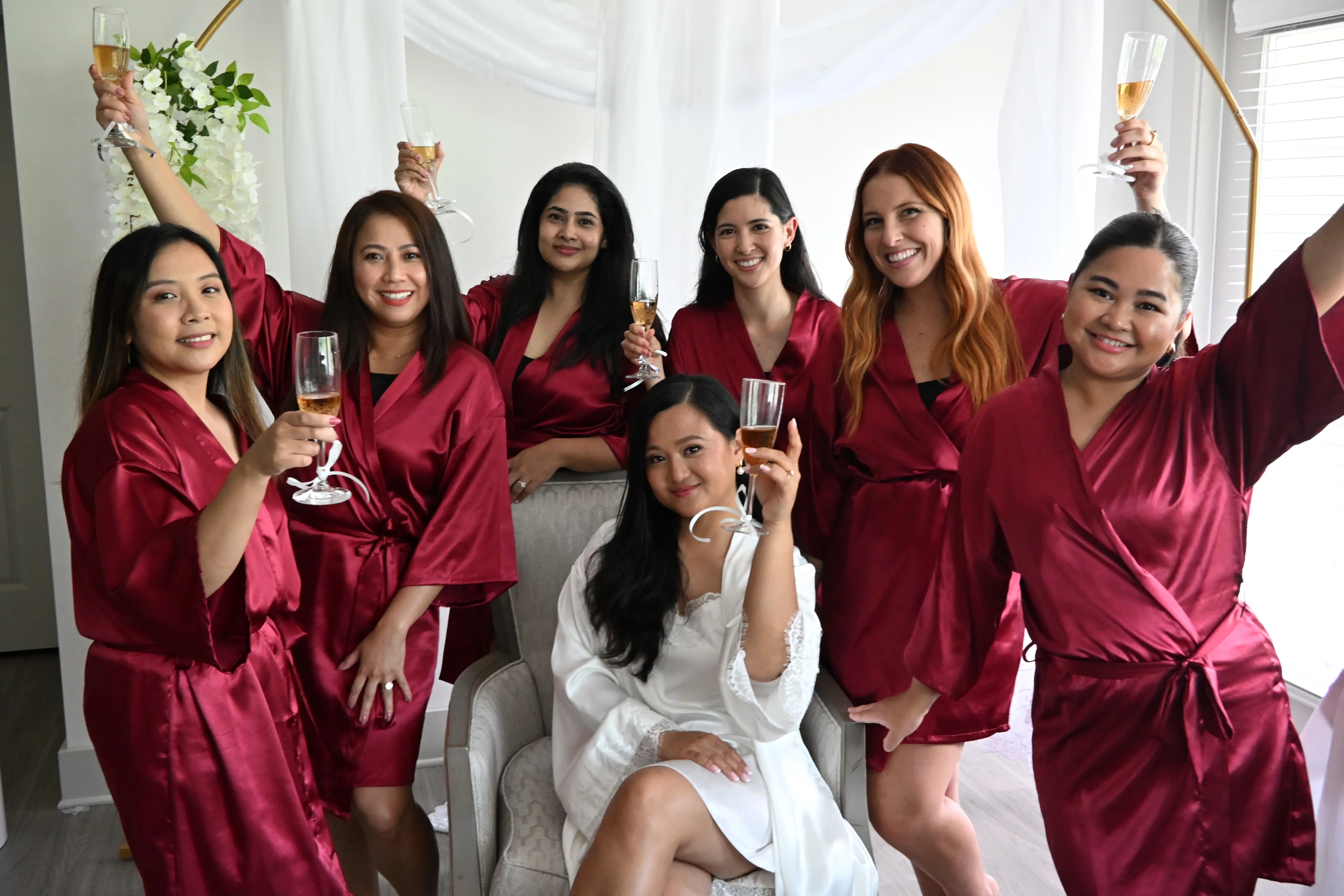 Bridesmaids raising champagne glasses around the bride during the wedding morning, Charlotte, NC