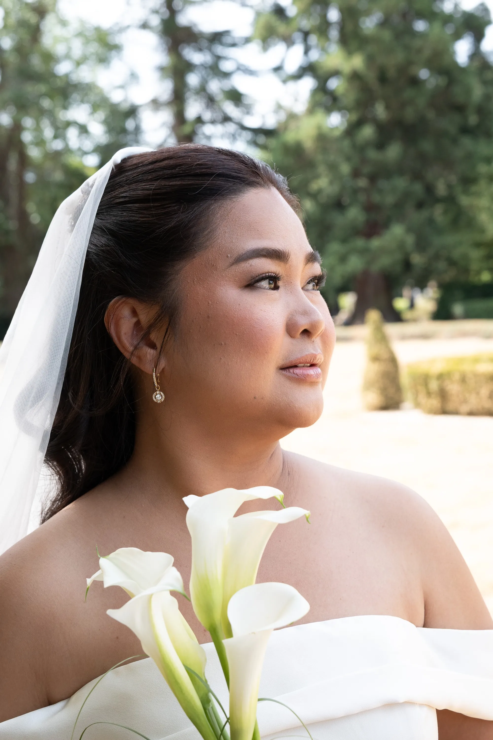 Bridal portrait of a bride in a veil holding white calla lilies, Heirloom, straight out of the camera before editing