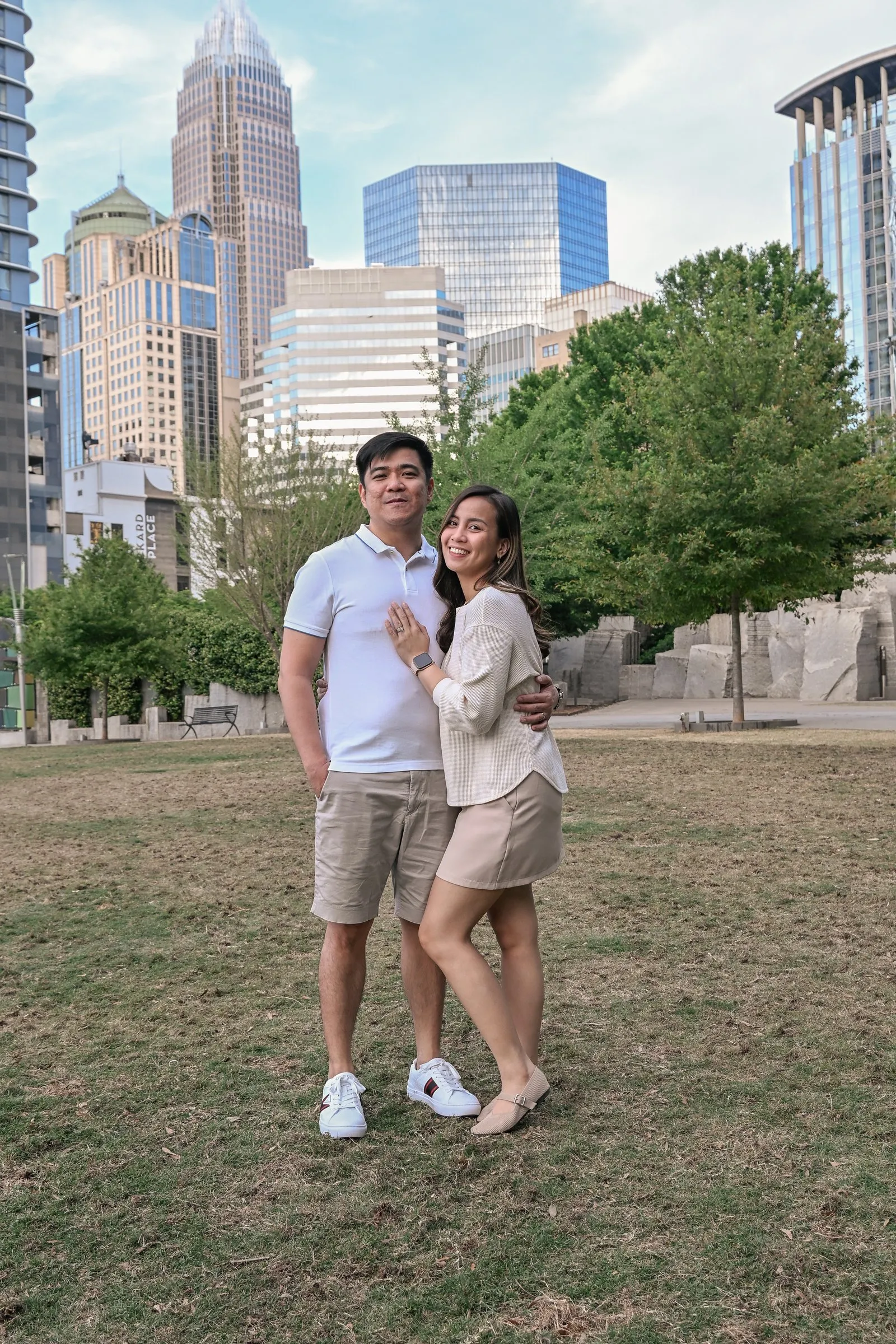 Jessica and Jet on the lawn with the Uptown Charlotte skyline rising behind them