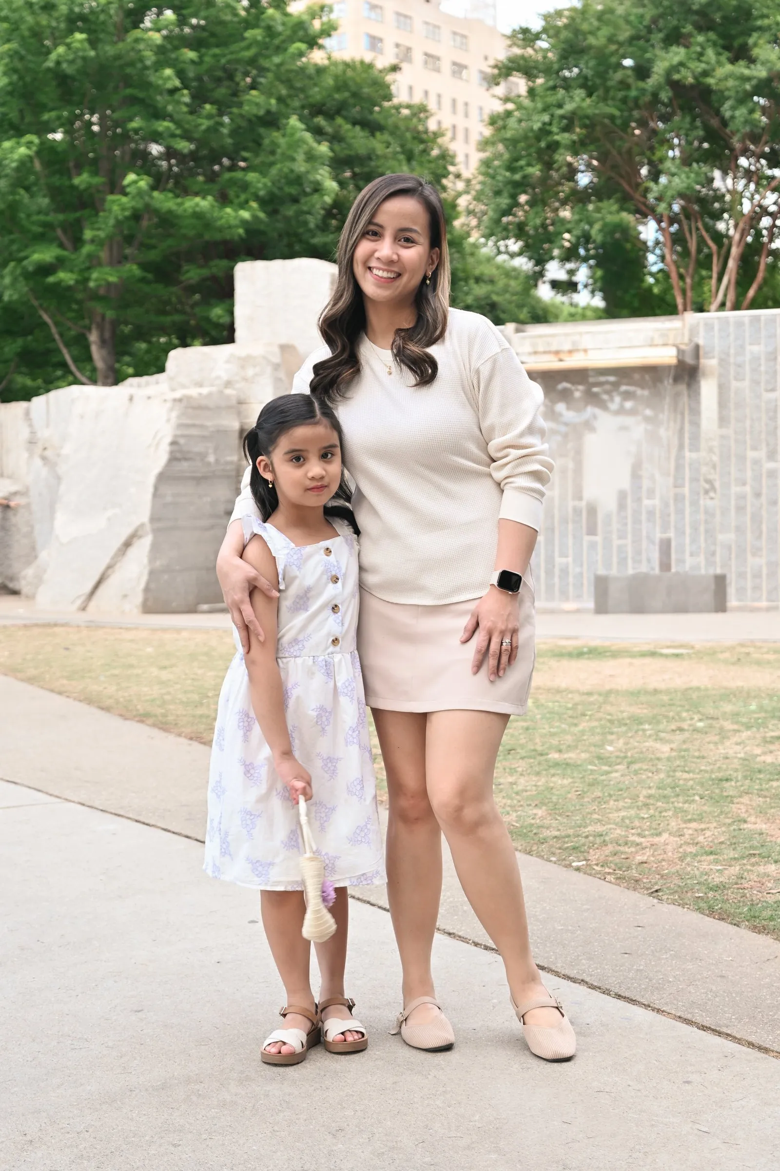 Jessica and her daughter side by side on the park path in front of the stone walls