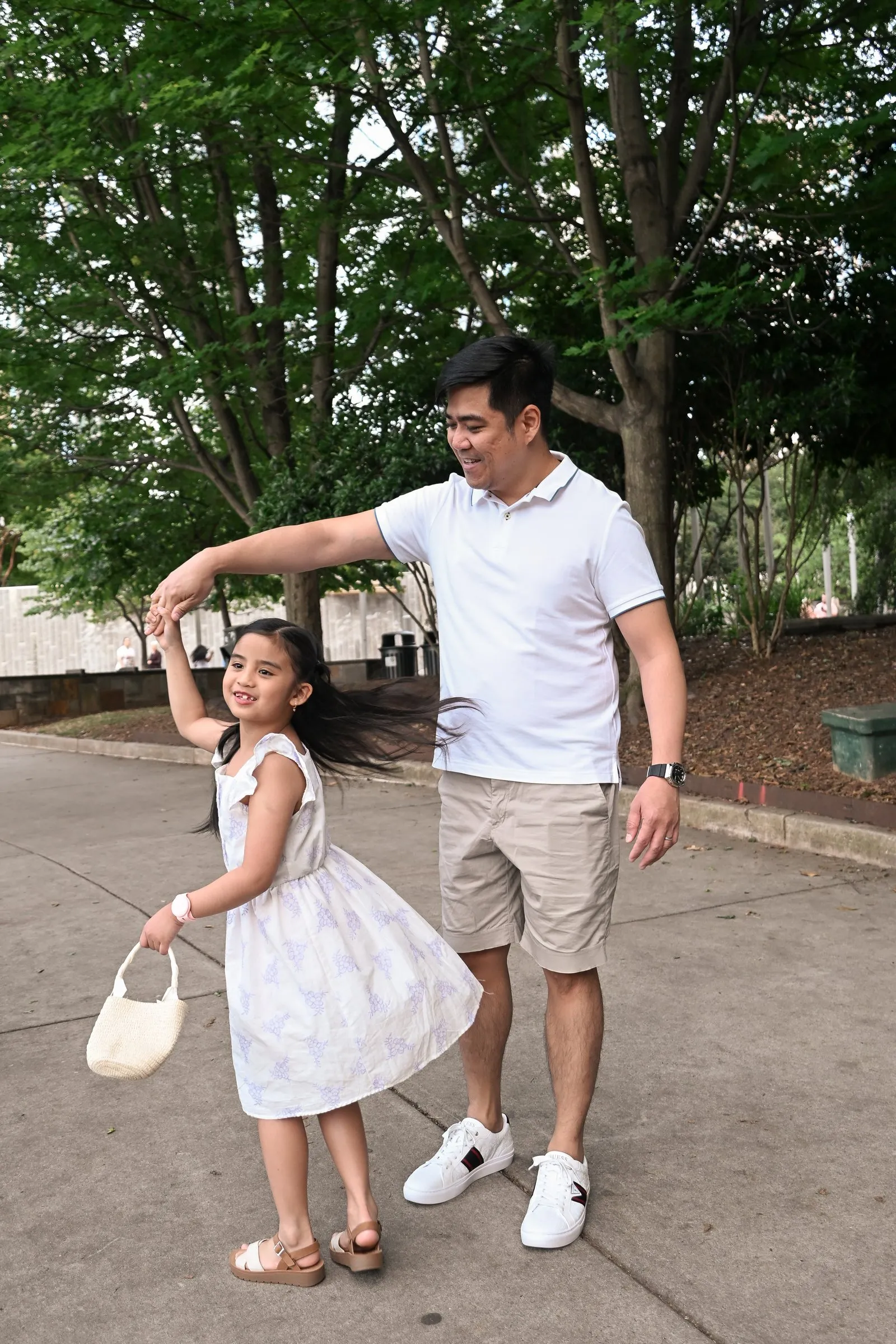 Their daughter spinning in her sundress while Jet guides the twirl