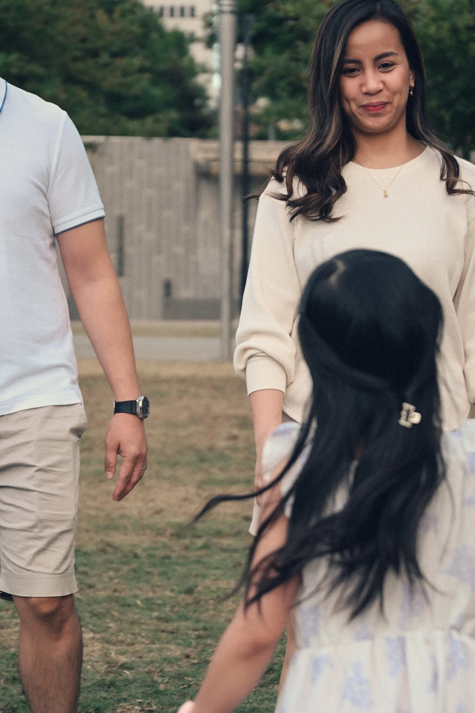 Their daughter walking toward Jessica across the lawn
