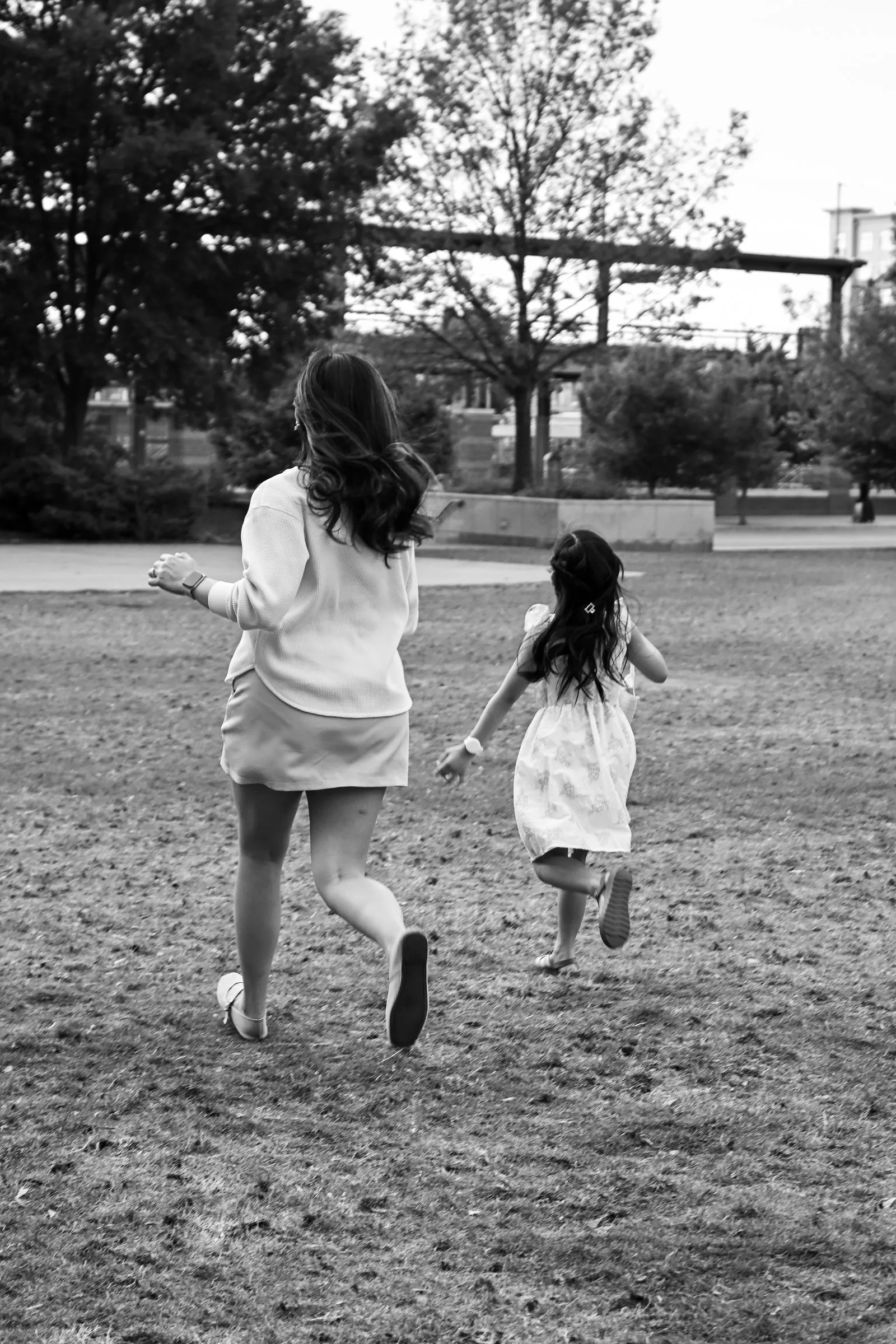 Black and white photograph of Jessica and her daughter running across the lawn