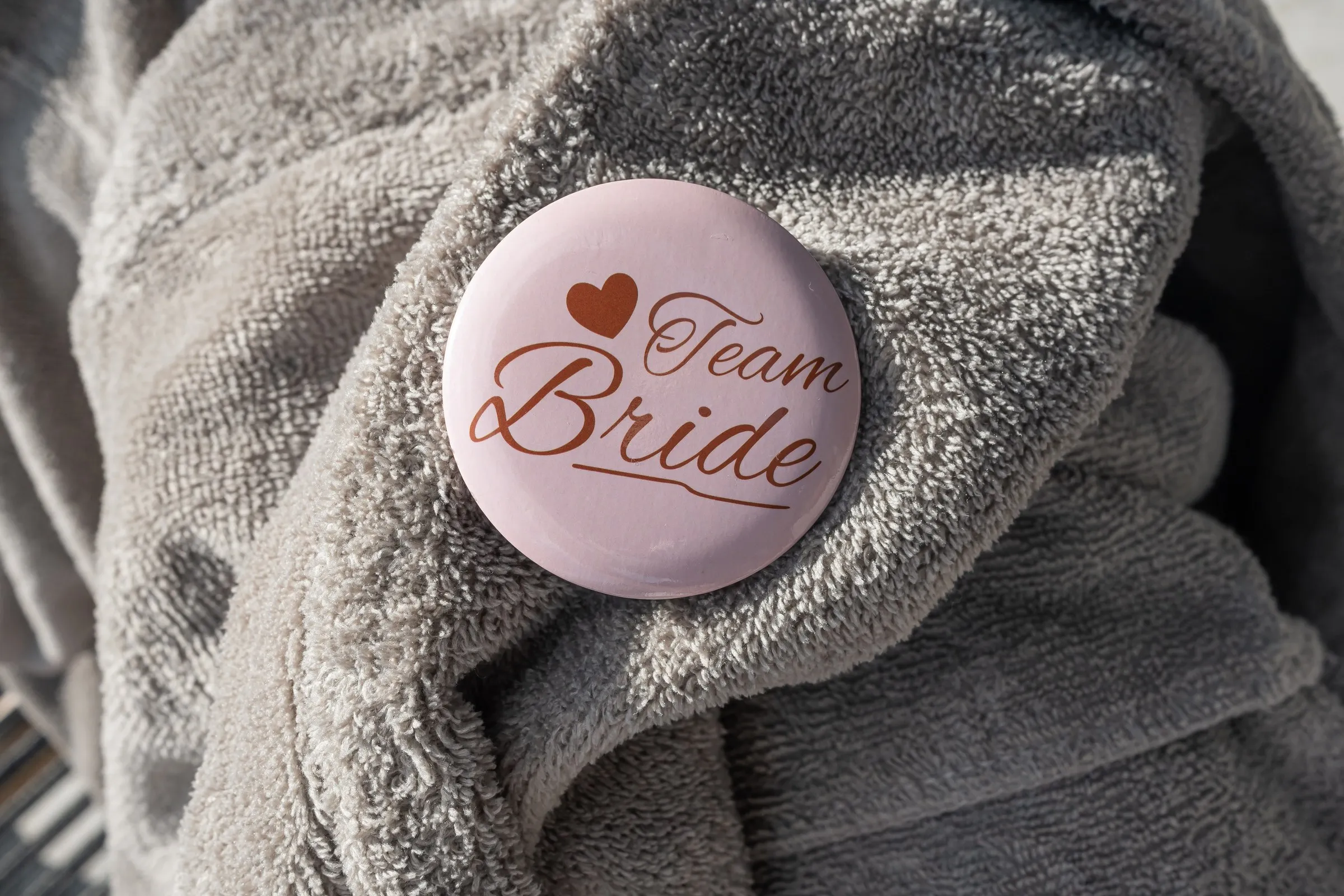 Close-up of a Team Bride pin on a plush robe