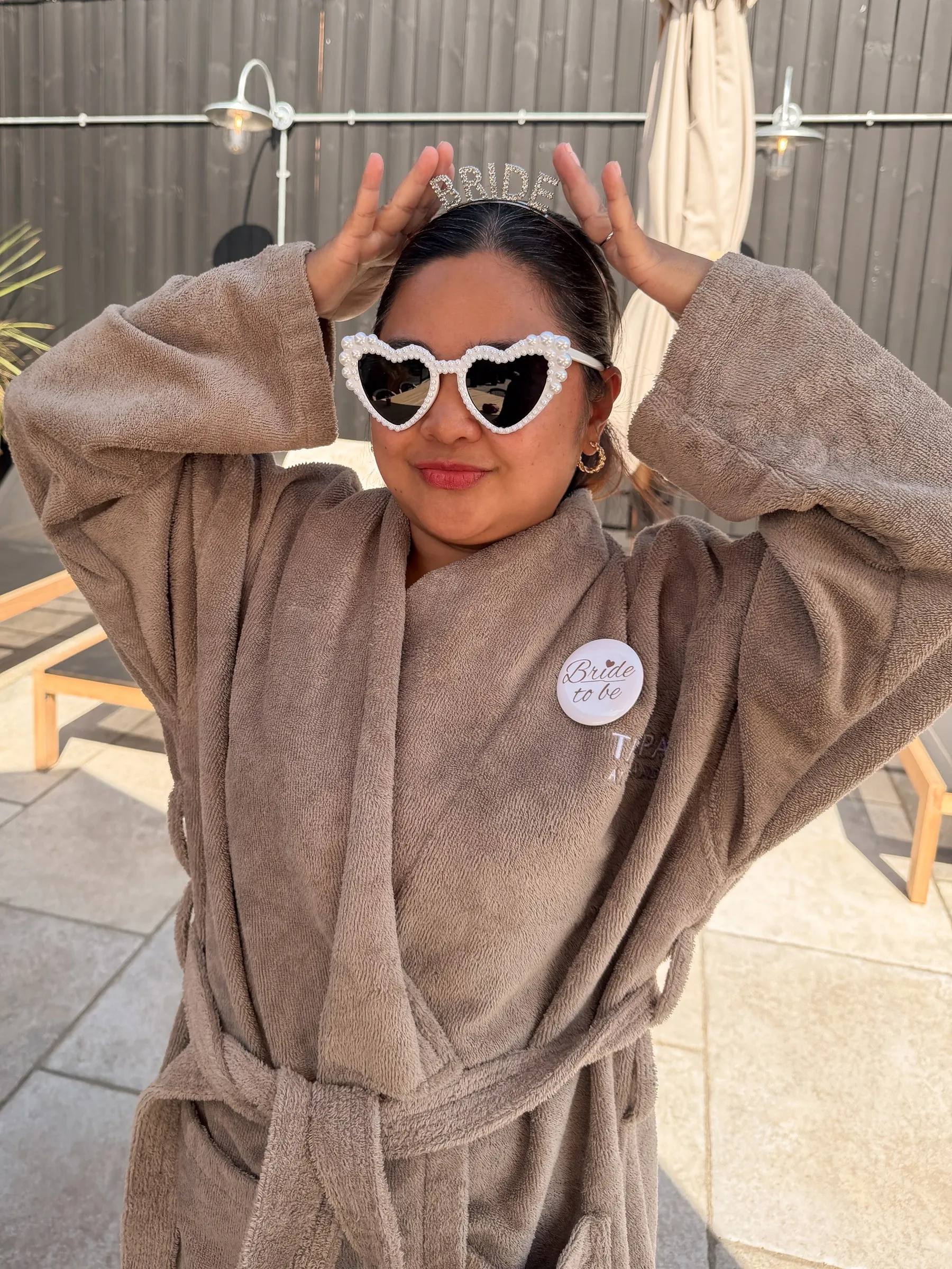 A guest in heart sunglasses posing with her hands on her head