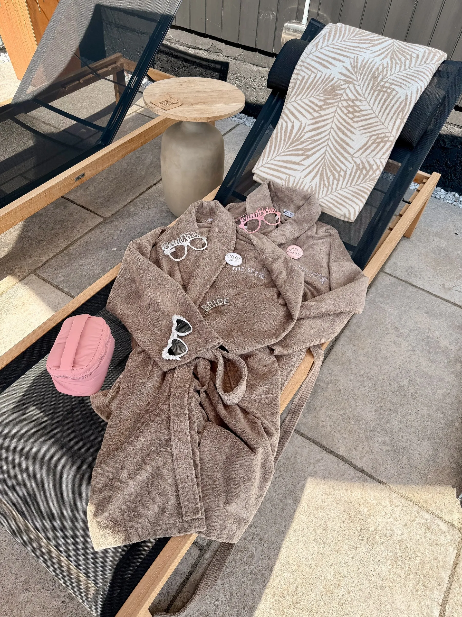 A robe, heart sunglasses and a pink bag left on a sun lounger