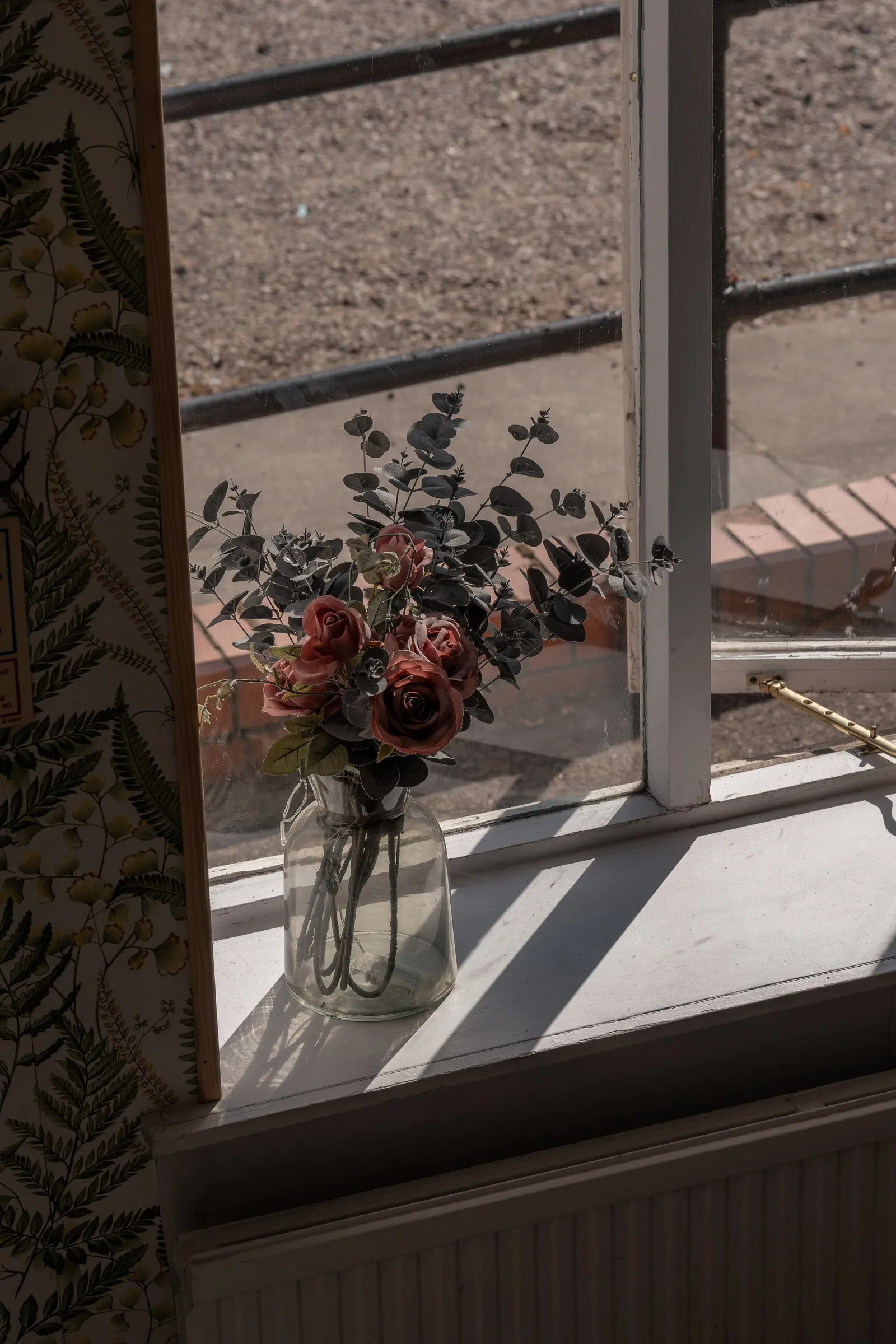Dried flowers in a vase on a sunny window ledge