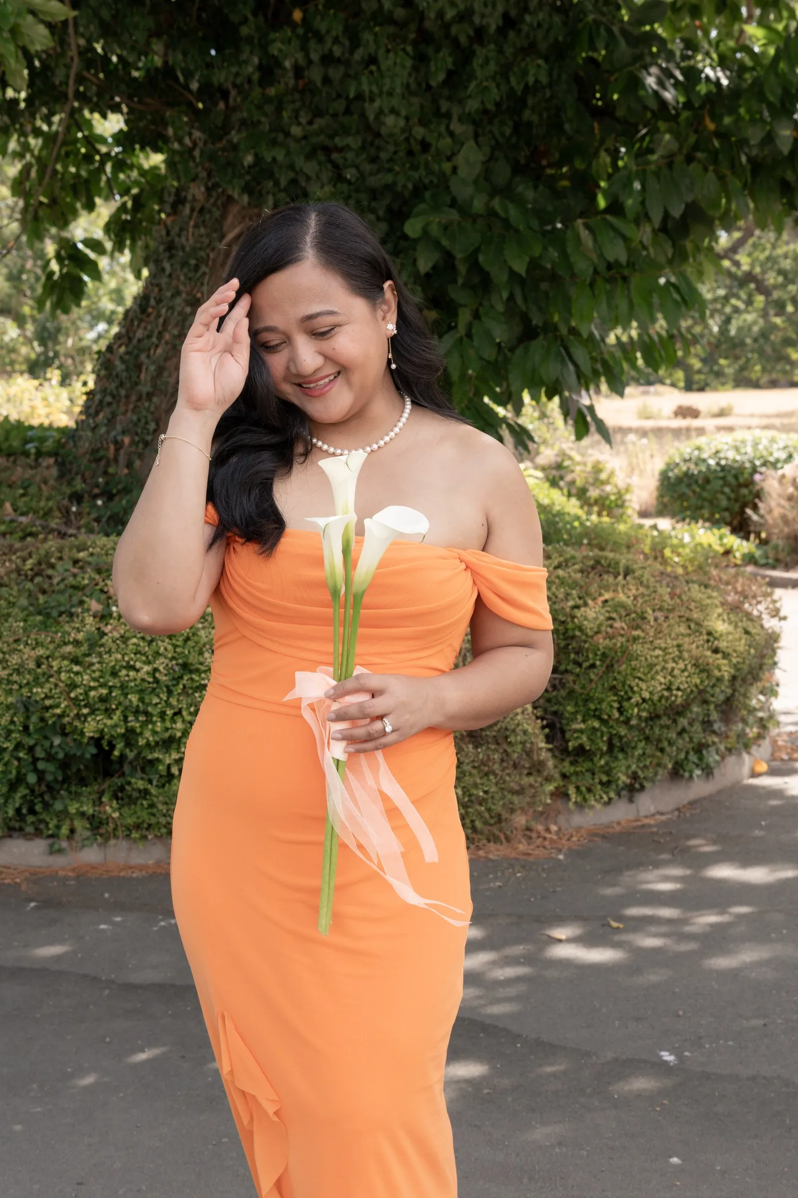 Bridesmaid in peach laughing as she brushes back her hair
