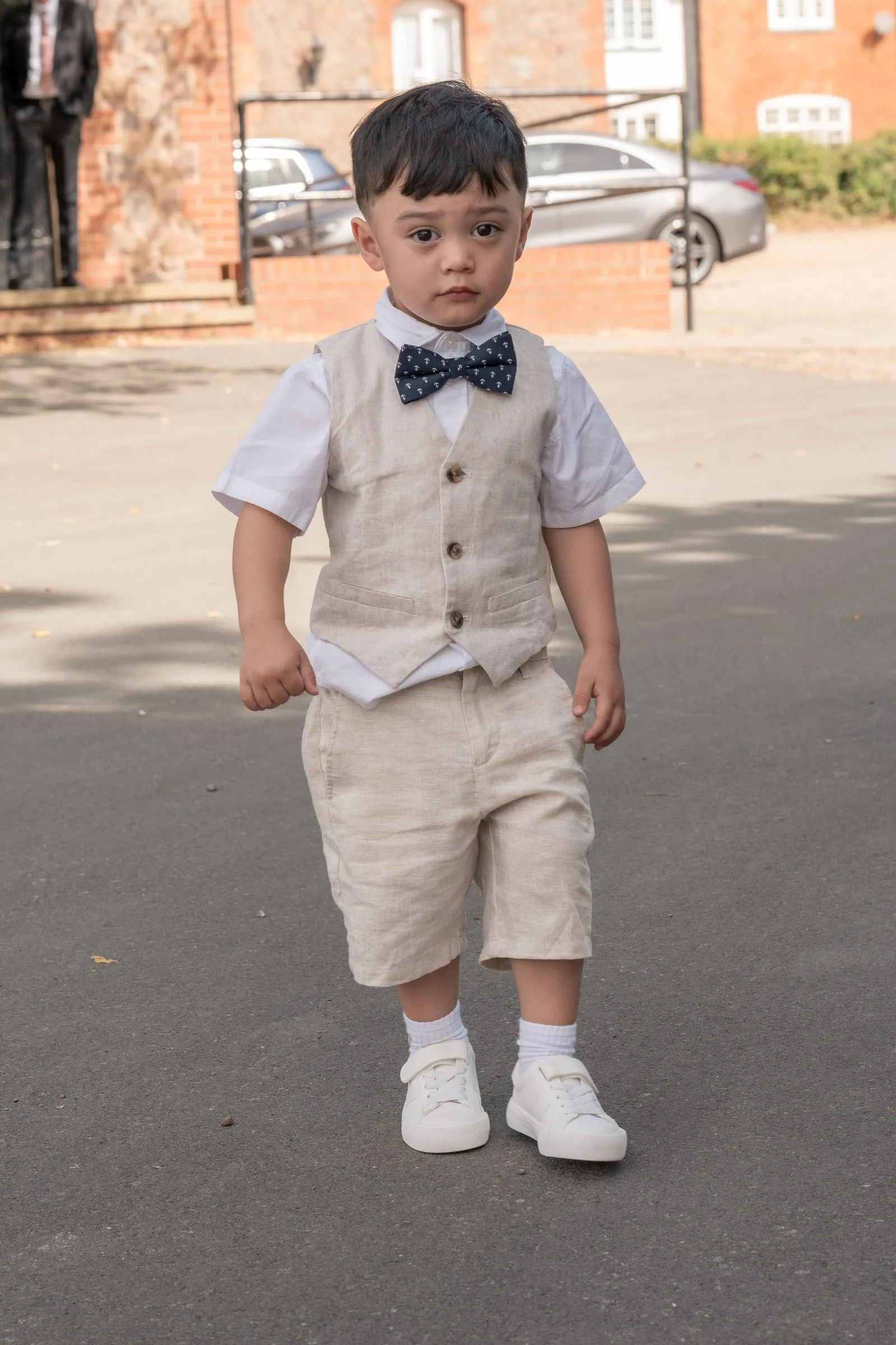 Mathelle's son walking toward the camera in his linen outfit
