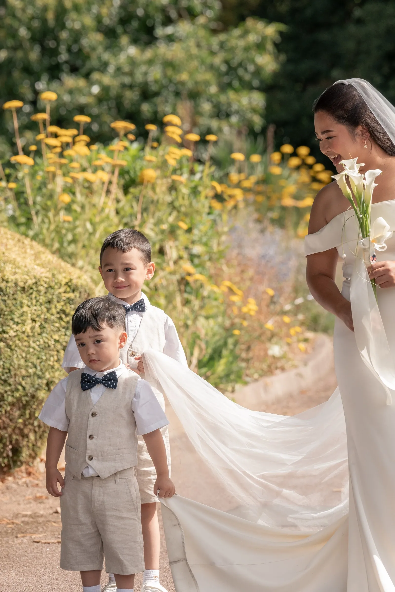 Mathelle's two sons in matching linen outfits beside her train