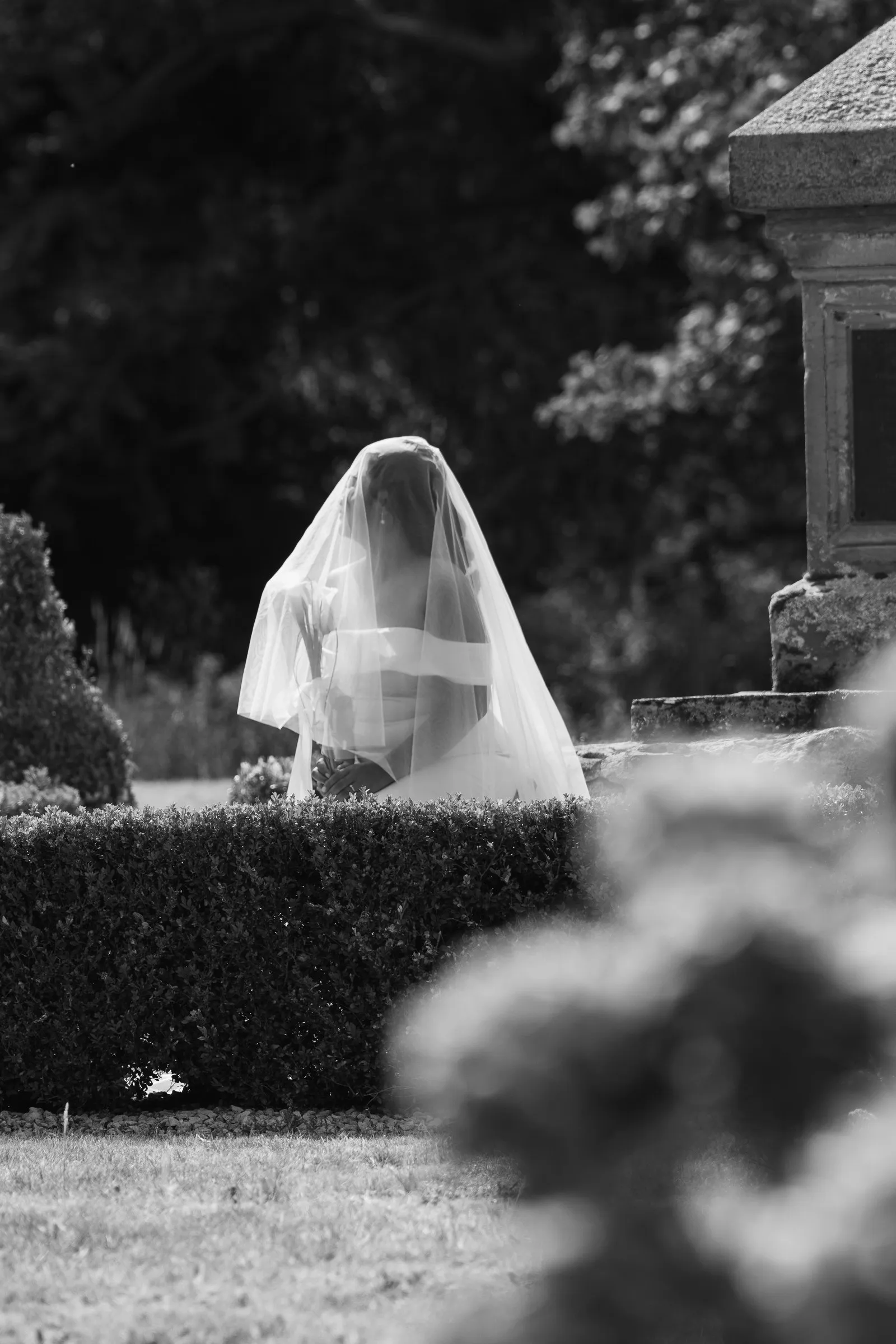 Black and white frame of Mathelle under her veil in the garden