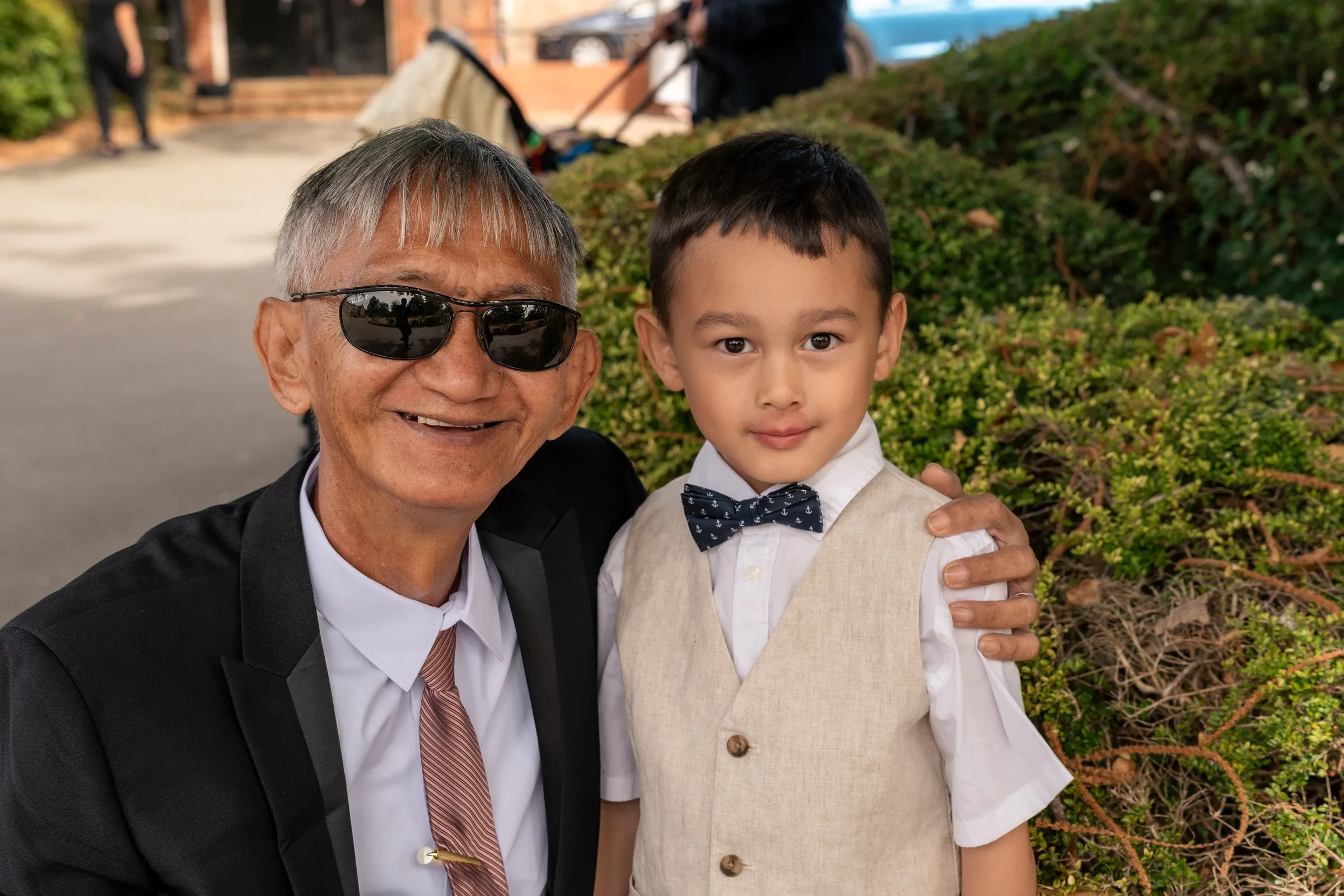 Mathelle's son smiling with a family member in sunglasses