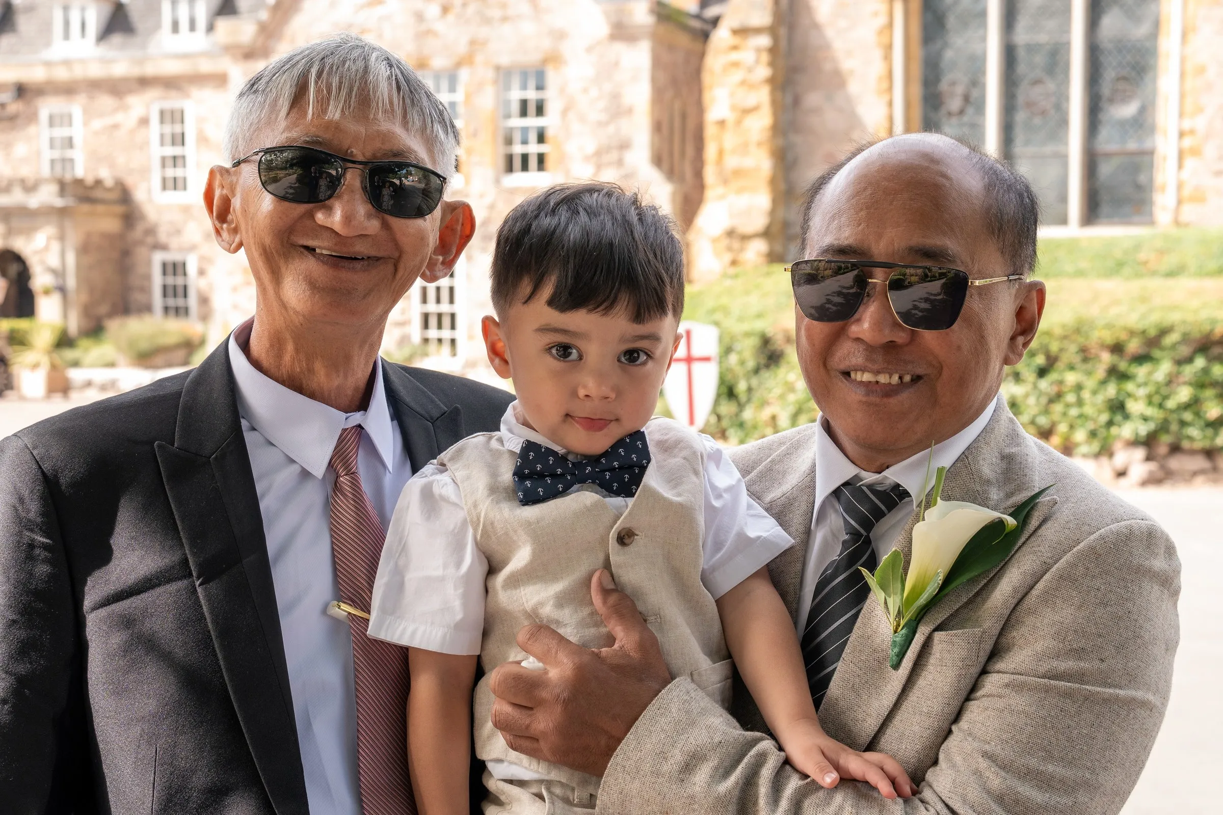 Mathelle's son held between two family members in suits
