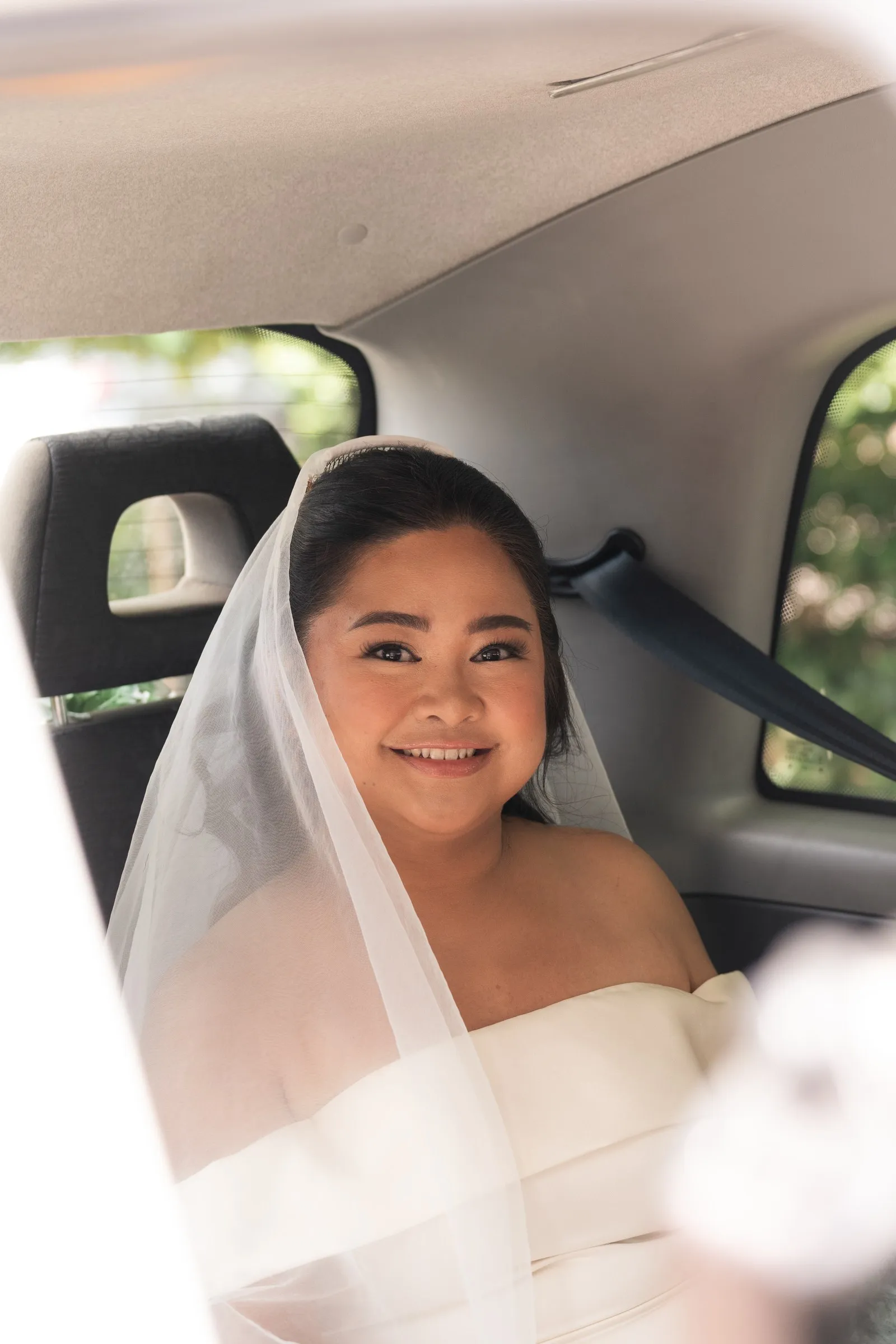 Mathelle smiling from the back seat of the wedding taxi