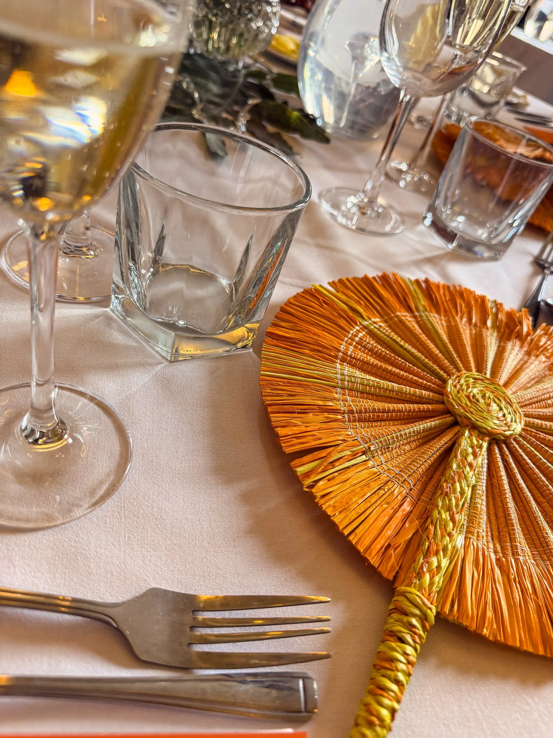 Gold and peach fan with glassware at the reception table