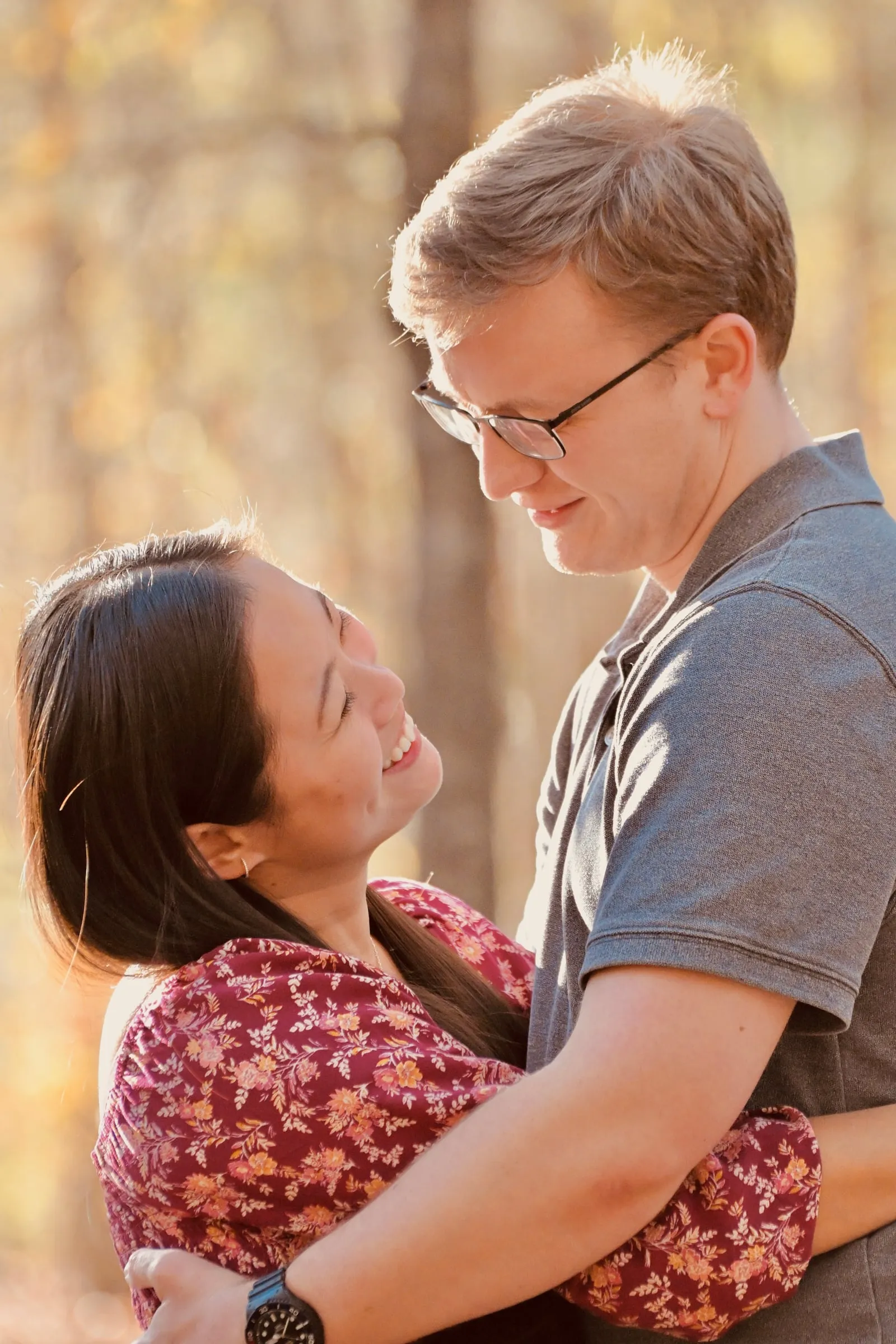 Mya and Jacob holding each other and laughing, sunlight catching the edge of her hair