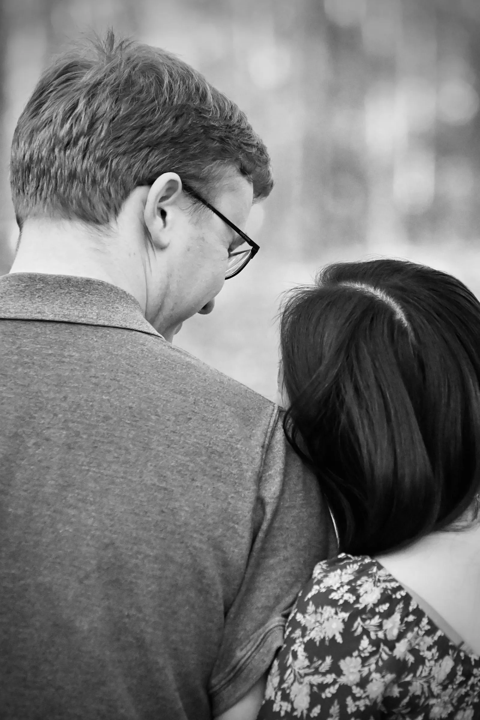 Black and white photograph of Mya resting her head against Jacob's shoulder as he looks down at her, Marvin Efird Park in Waxhaw, NC