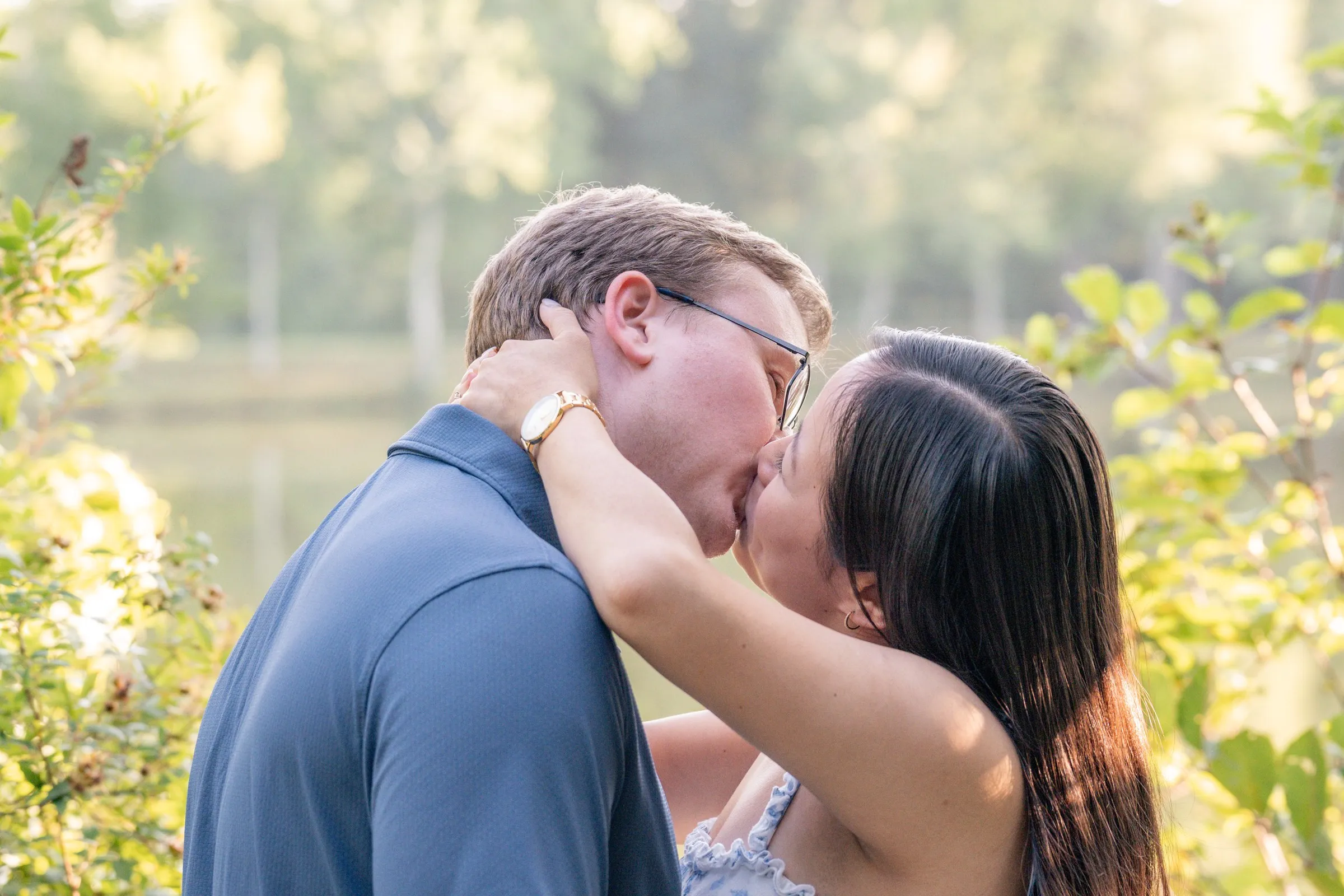 Mya and Jacob kissing beside the pond at Marvin Efird Park