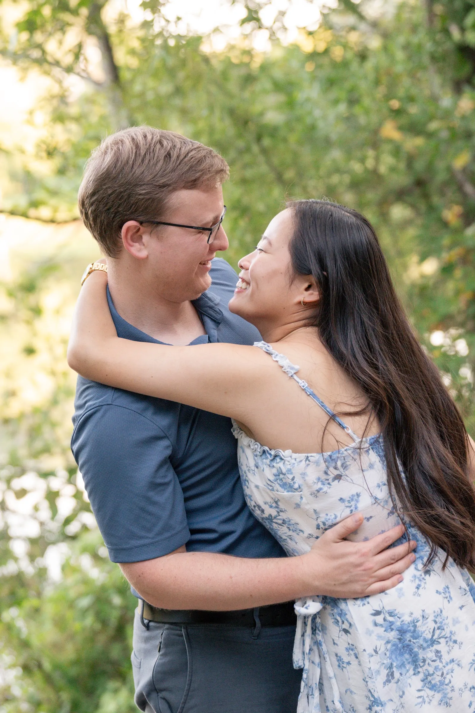 Mya wrapping her arms around Jacob's neck, laughing in soft backlight