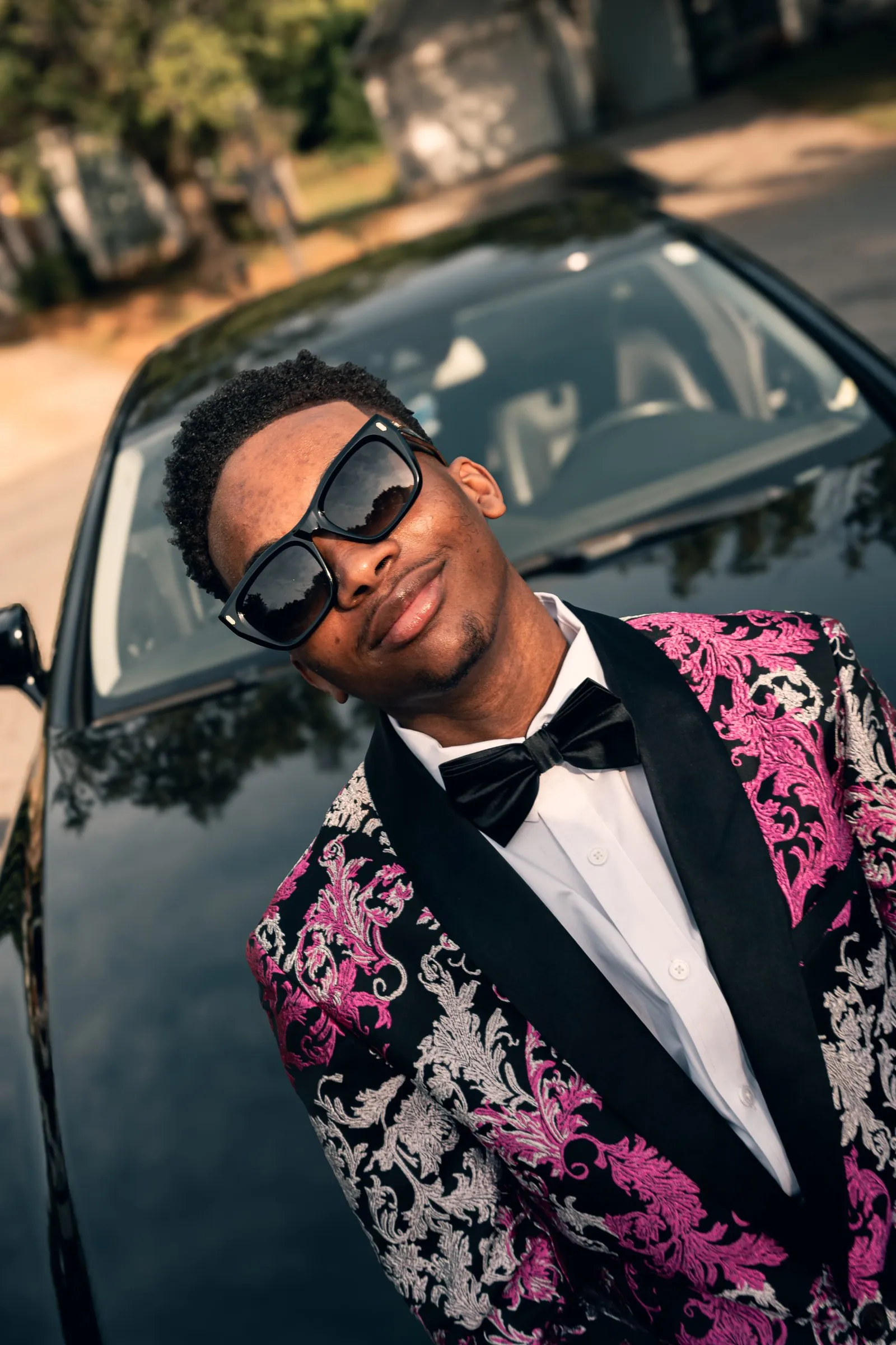 Head tilted against the windshield, sunglasses on