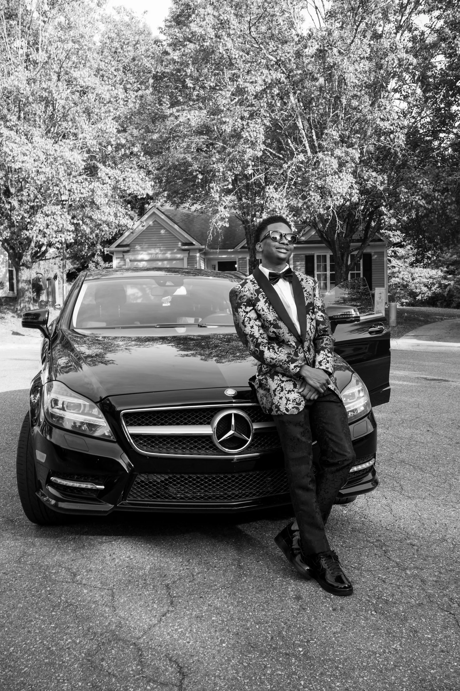 Black and white photograph of him perched on the Mercedes bumper