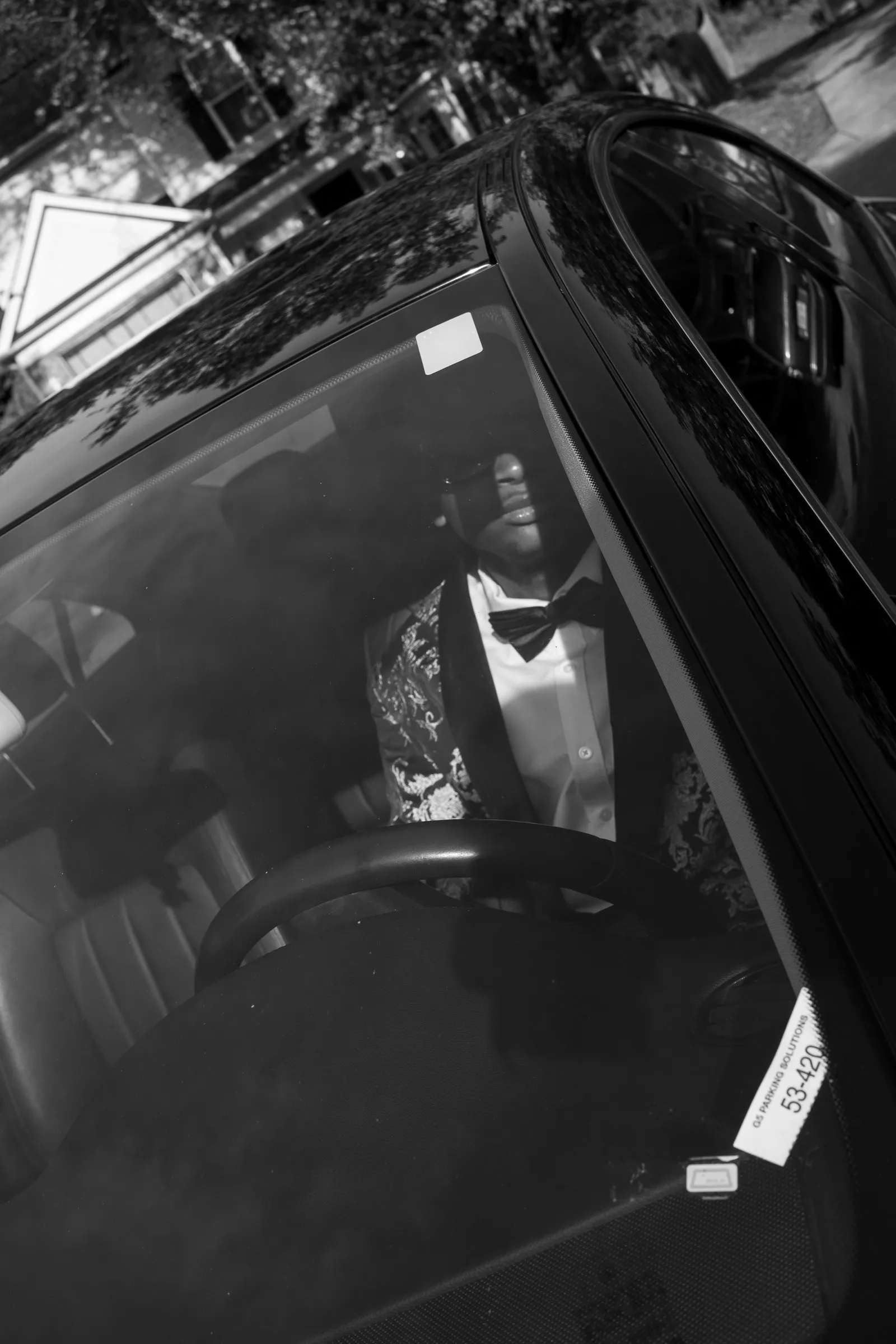 Black and white photograph of his reflection in the Mercedes window