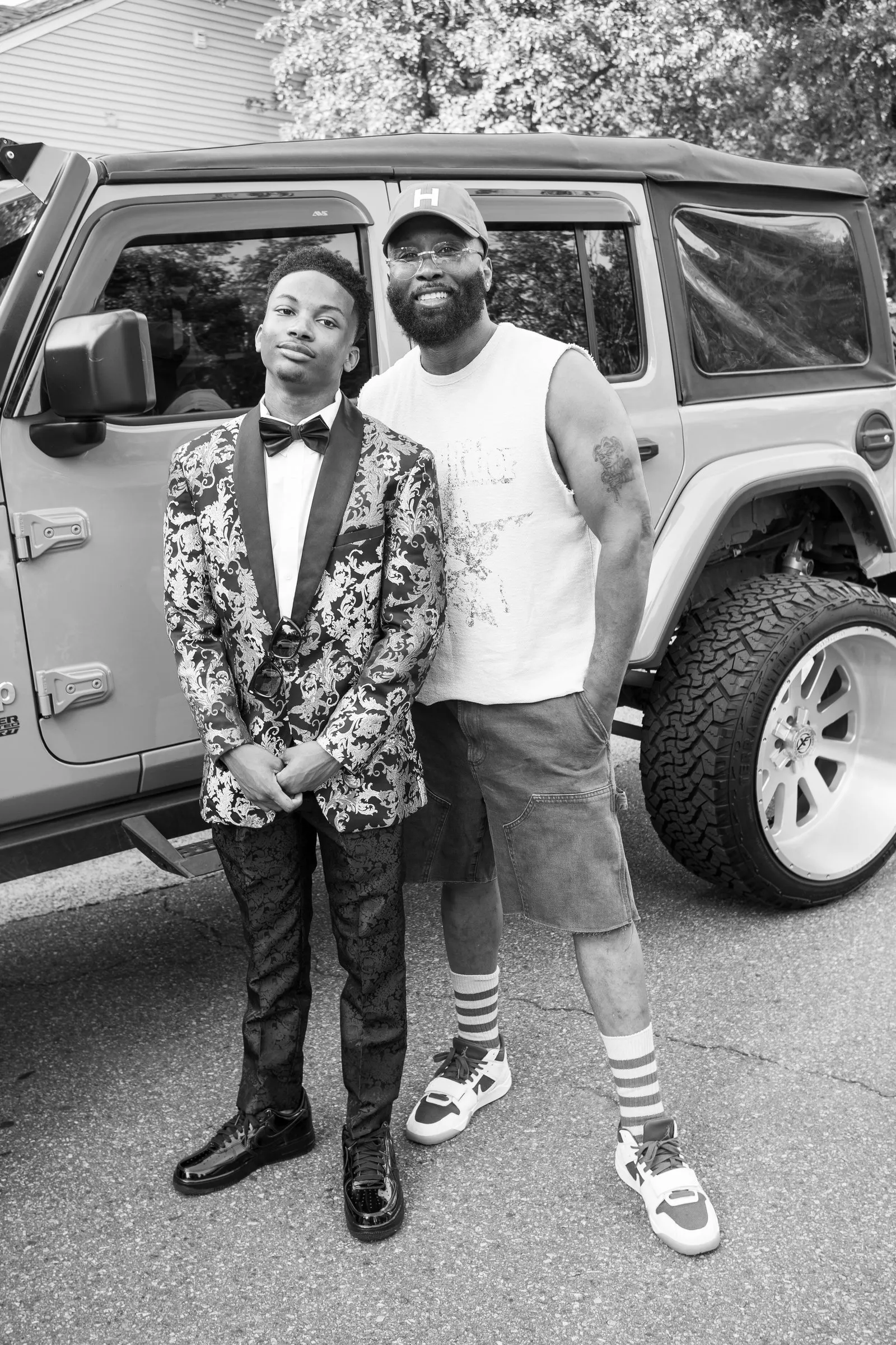 Black and white photograph of him with a man in a cap beside the Jeep