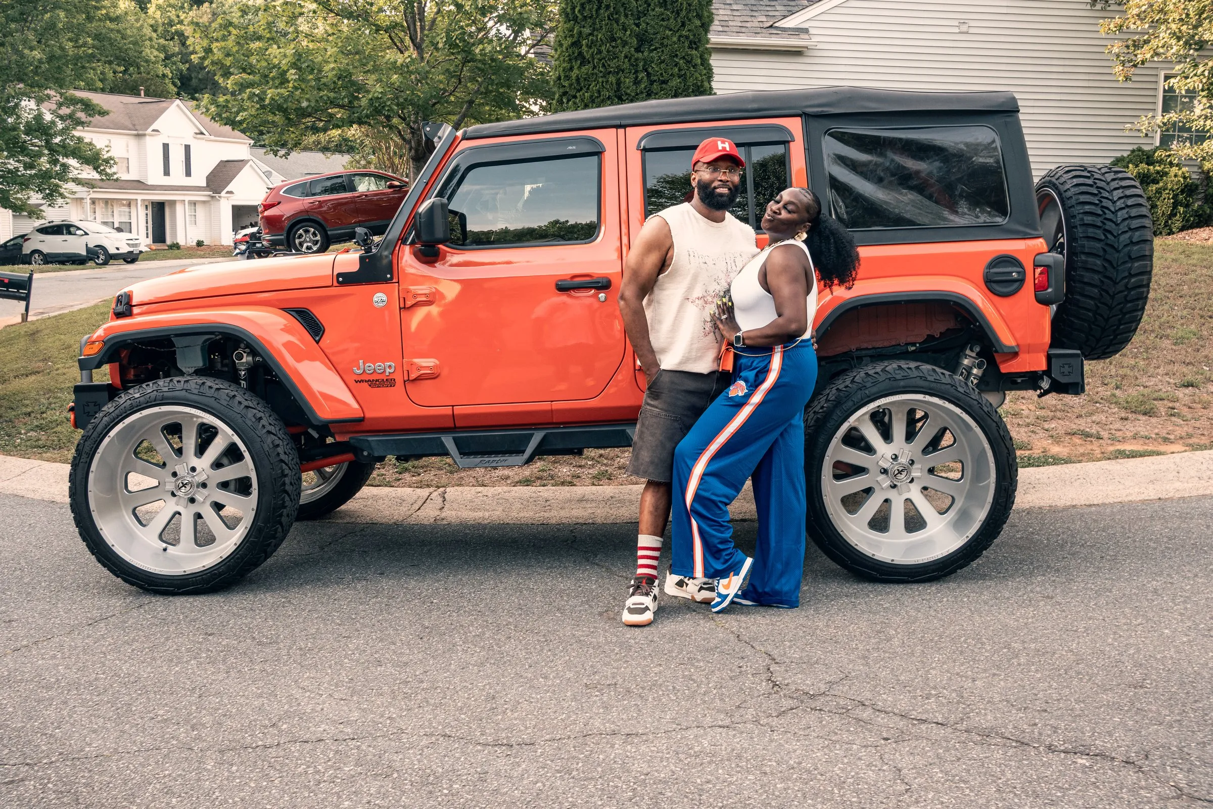 The couple in front of the orange Jeep Wrangler
