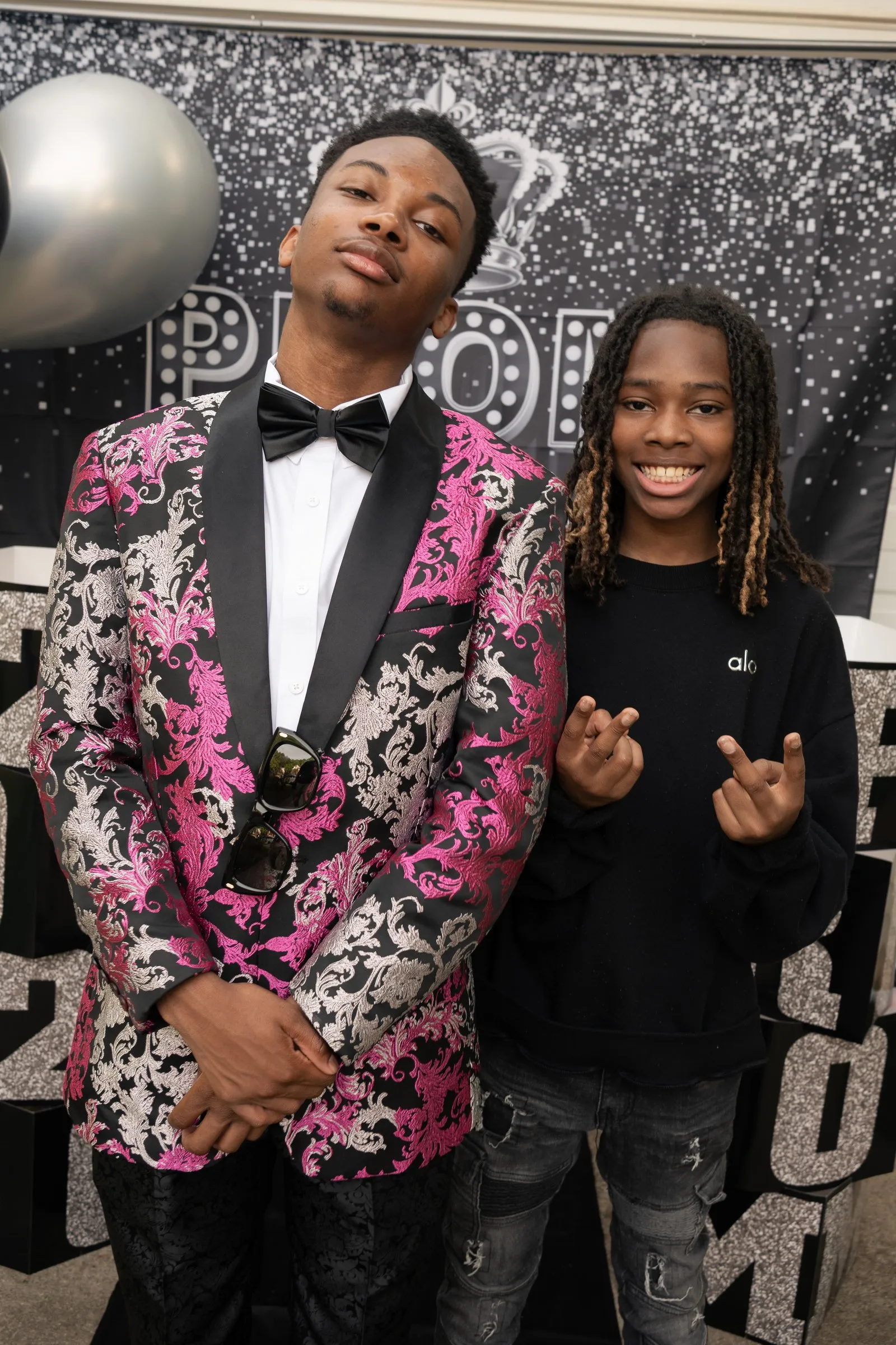 He poses with a young friend in a black hoodie at the backdrop