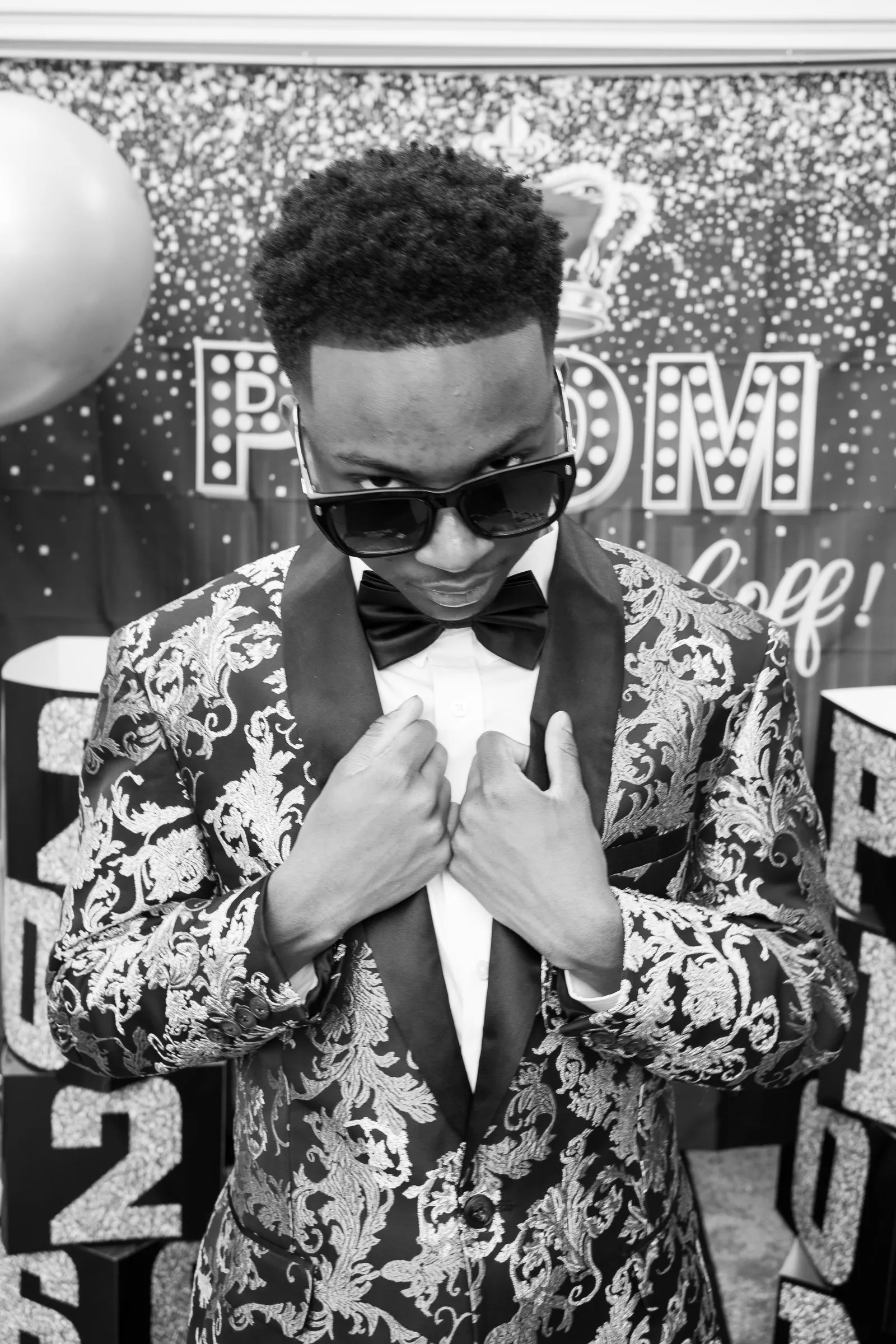 Black and white photograph of him adjusting his lapels