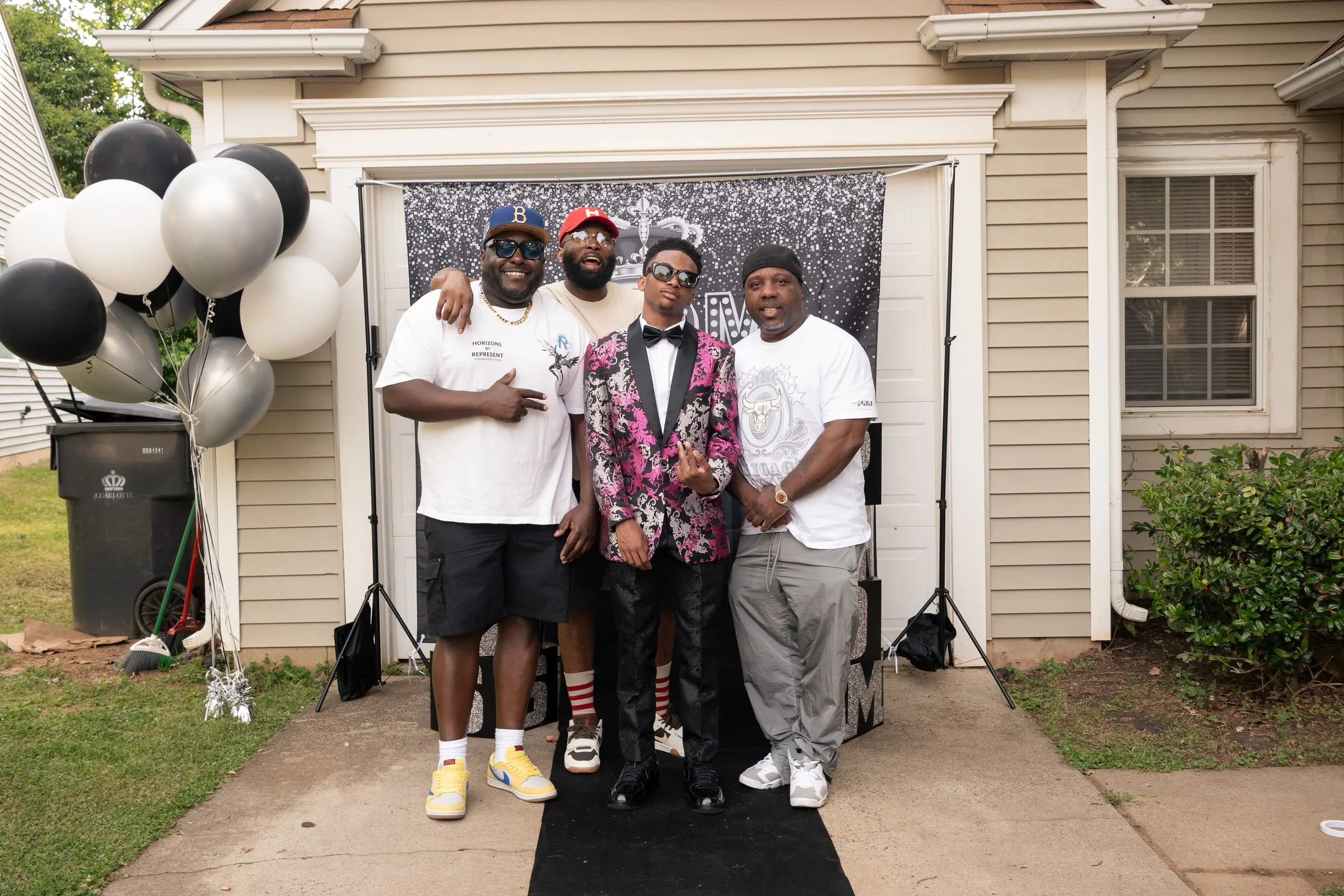 Wide view of the garage backdrop with him and three men on the runner
