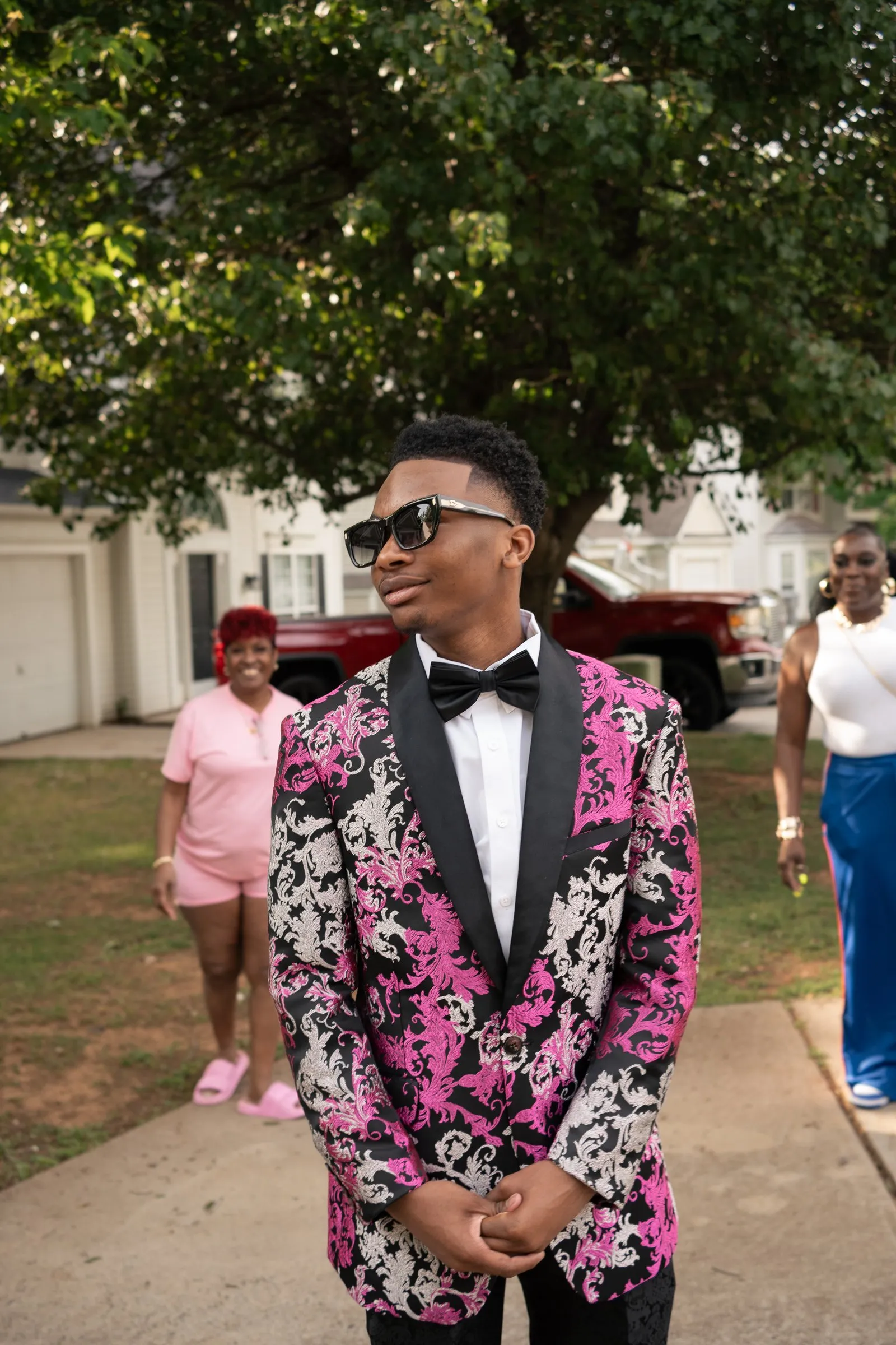 Portrait on the front walk in his pink floral jacket as guests arrive