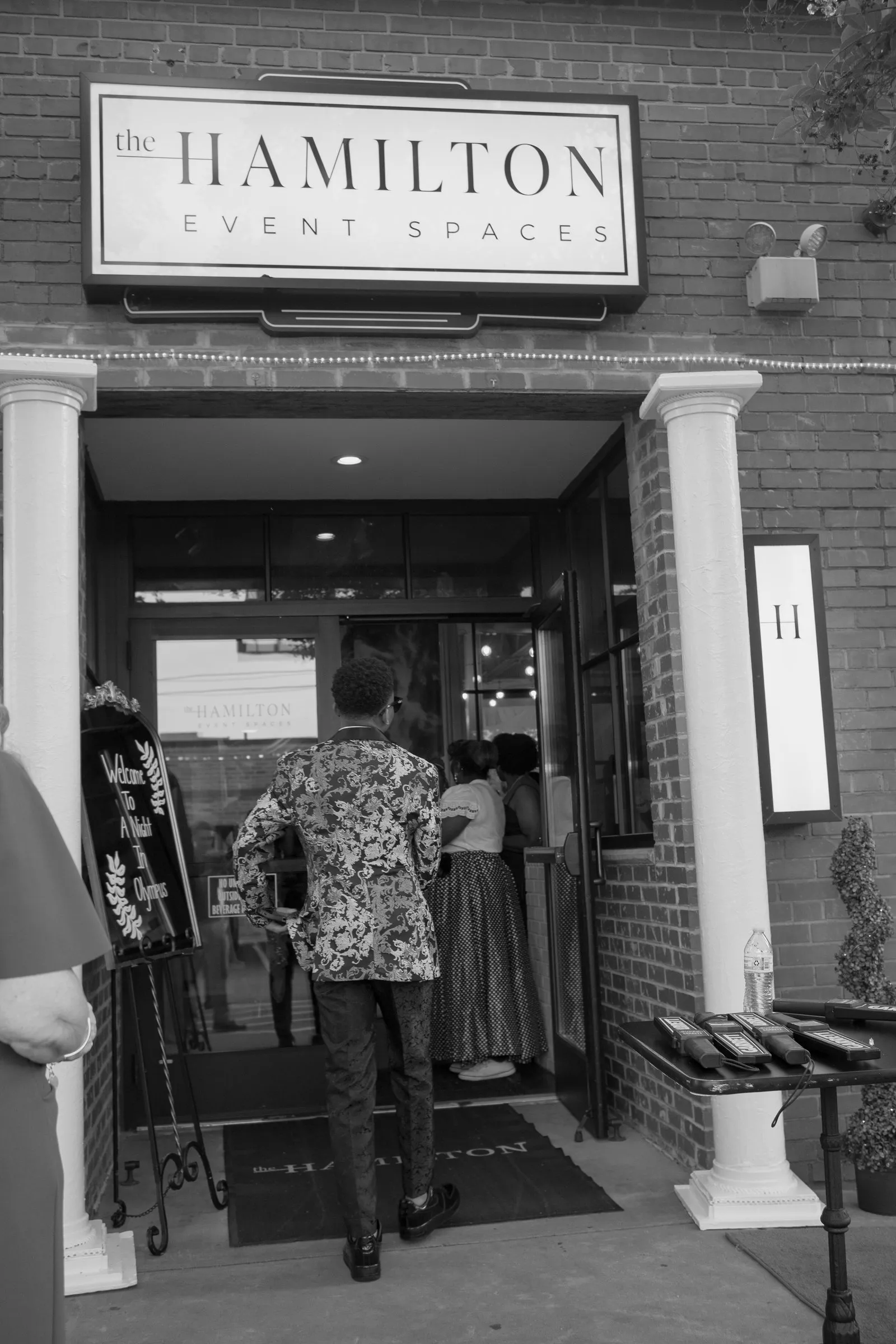 Black and white photograph of him walking into The Hamilton Event Spaces for prom