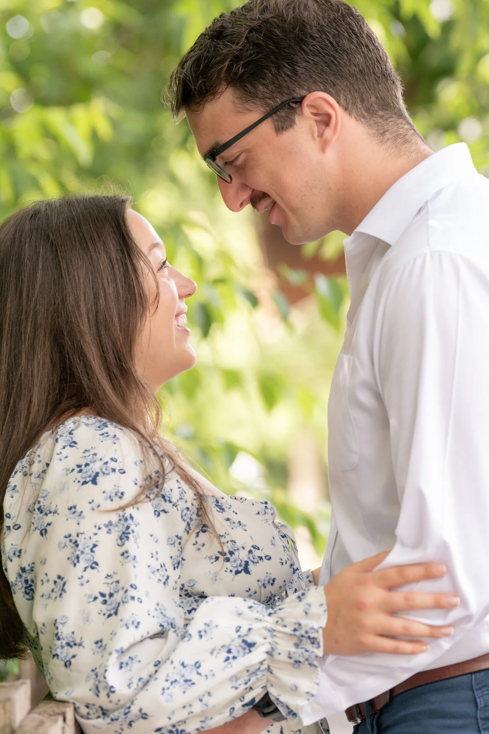 Spencer leaning in close as Kayla smiles up at him in her blue floral dress