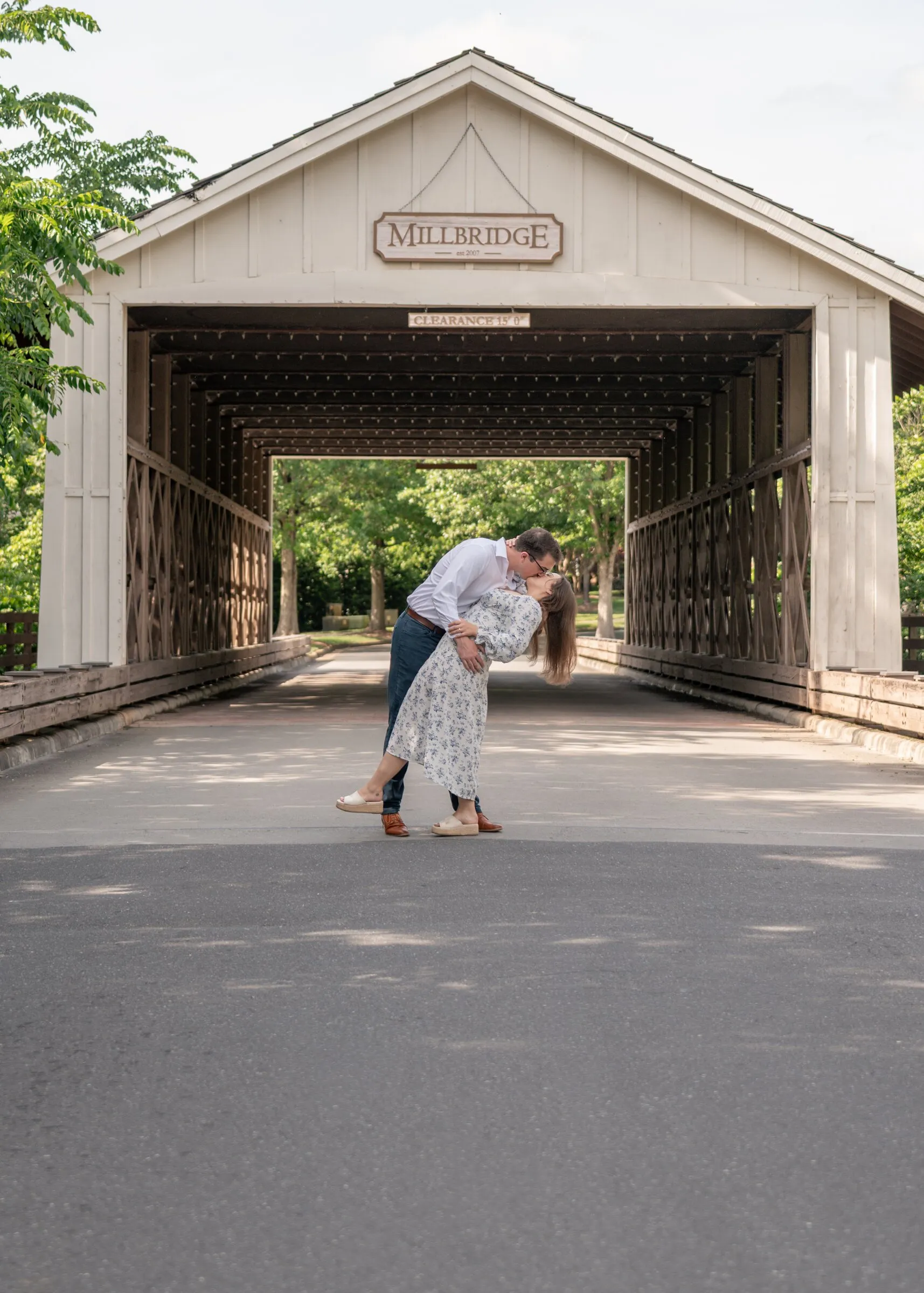 Spencer dipping Kayla for a kiss inside the white Millbridge covered bridge