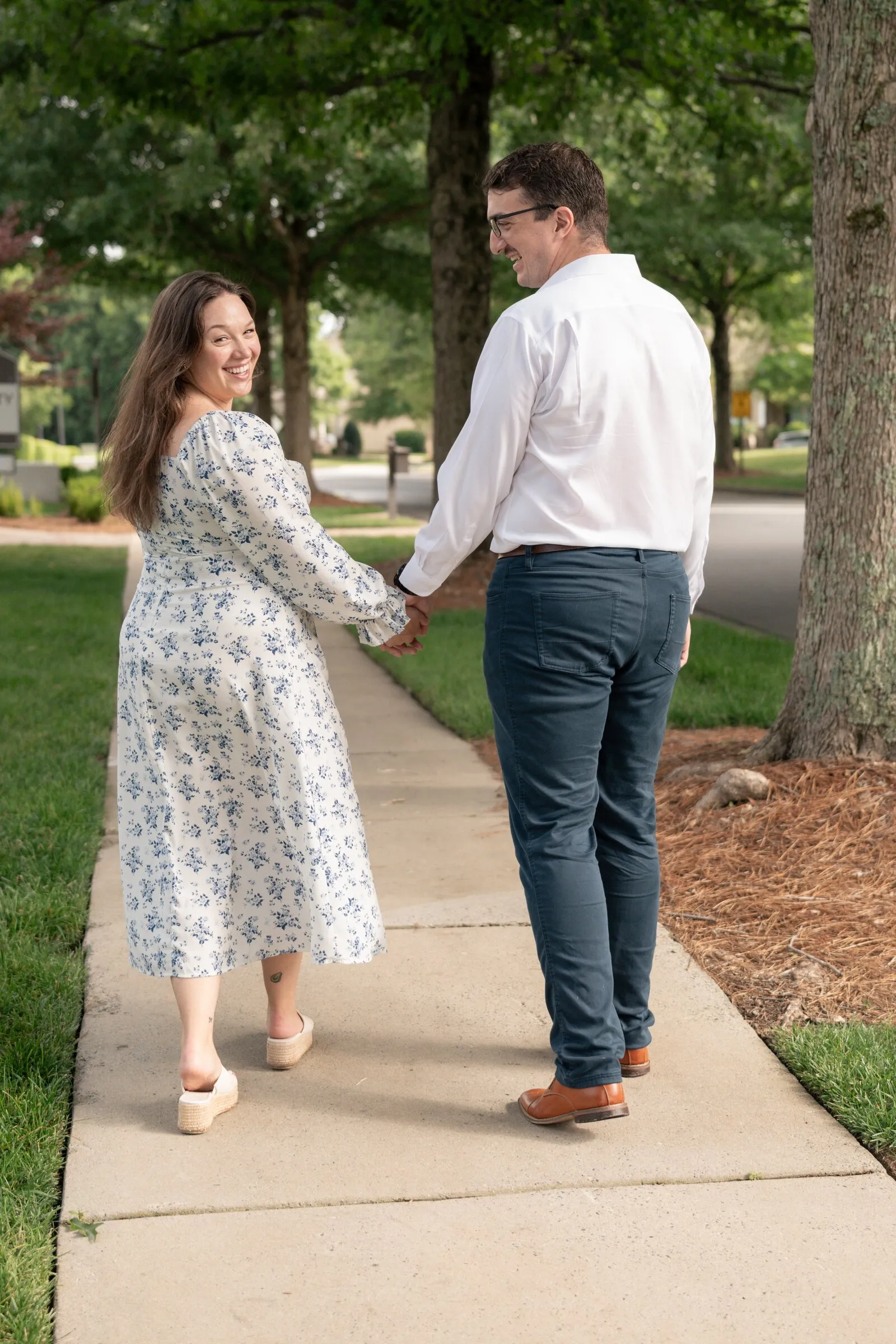 Kayla smiling back at the camera as Spencer leads her down the sidewalk
