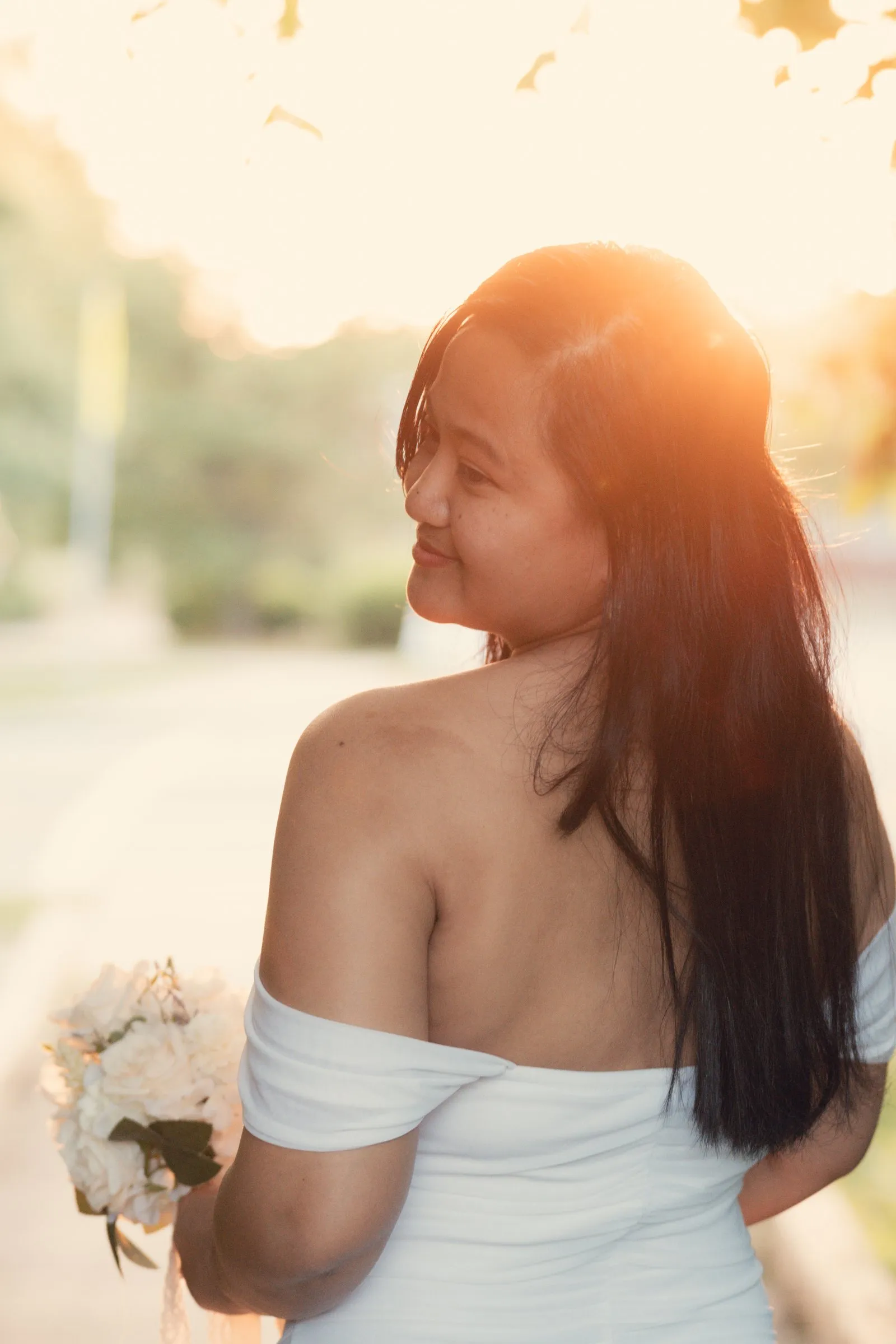 Winnie looking back over her bare shoulder with the setting sun glowing through her hair