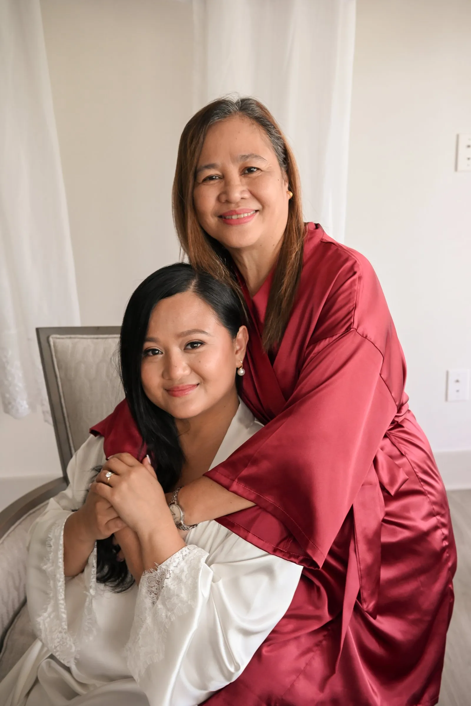 Winnie's mom wrapping her arms around her from behind as Winnie holds her hands